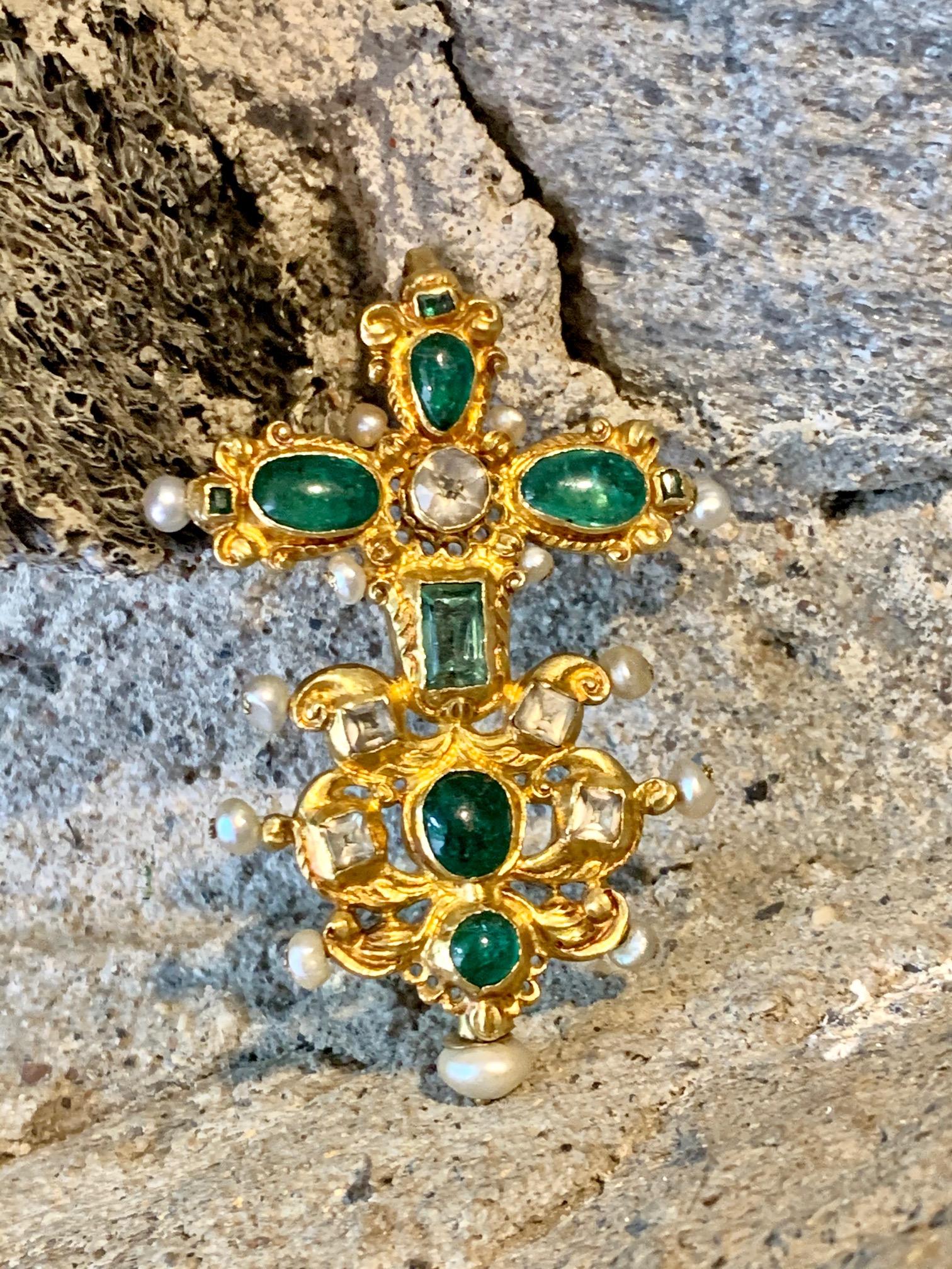 This antique 22 karat yellow gold pendant features Emeralds of various cuts, along with Pearls and white unidentified gemstones. 
It is stamped 