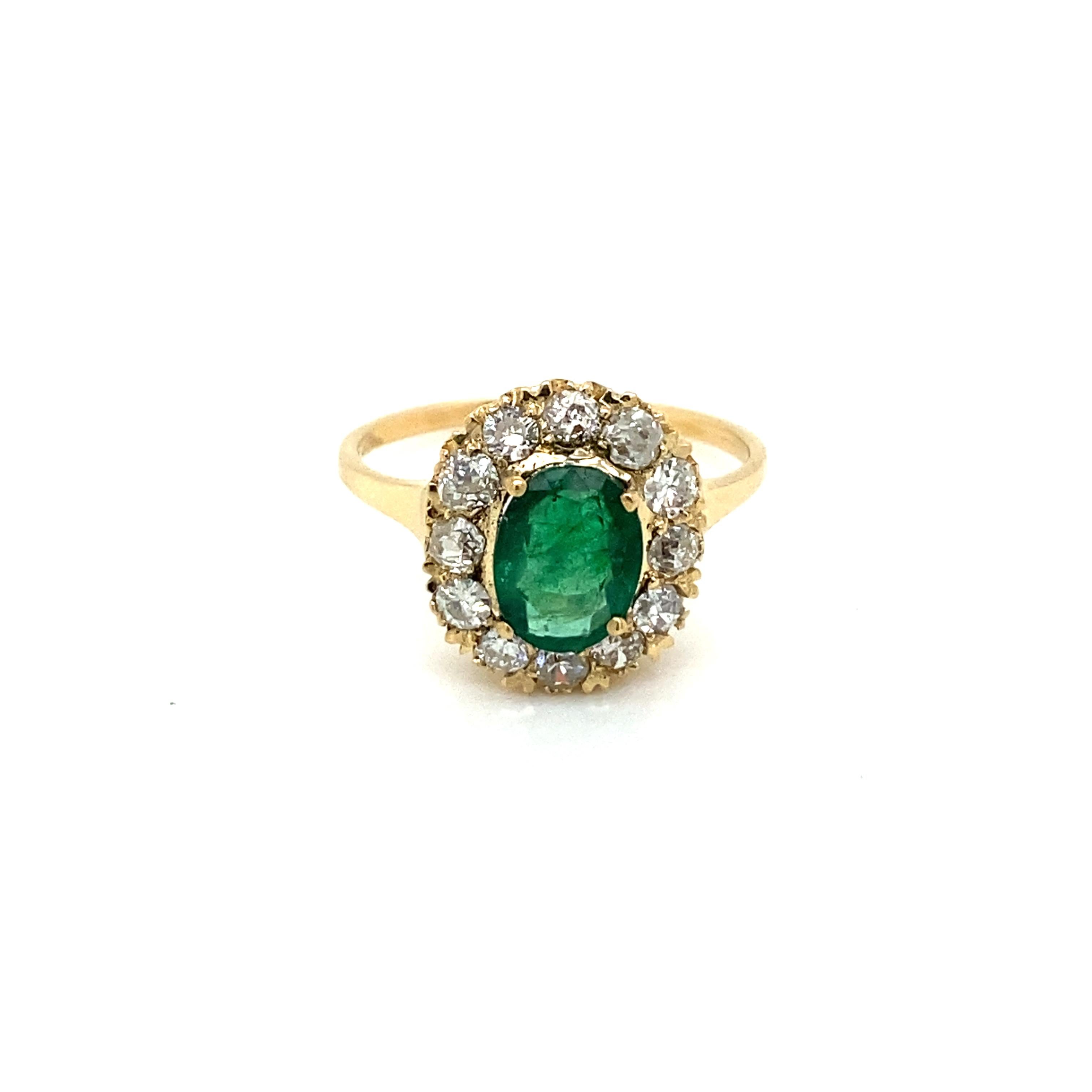 Beautiful 18k yellow gold cluster ring. It features in the center one vivid Natural Emerald oval shape, origin Zambia, weight 1.30 ct., surrounded by Sparkling Old mine cut diamond weighing .70 ct. all together, graded I color Vs2.  
Circa