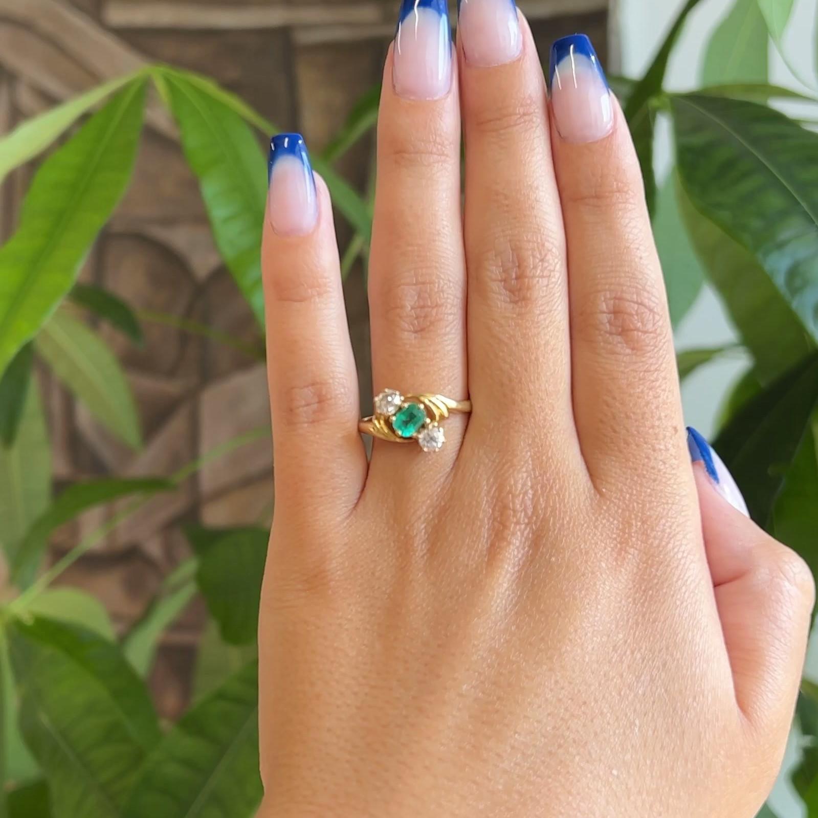 One Antique Emerald Old Mine Cut Diamonds 18 Karat Yellow Gold Three Stone Ring. Featuring one mixed cut emerald weighing approximately 0.45 carat. Accented by two old mine cut diamonds with a total weight of approximately 0.65 carat, graded I color