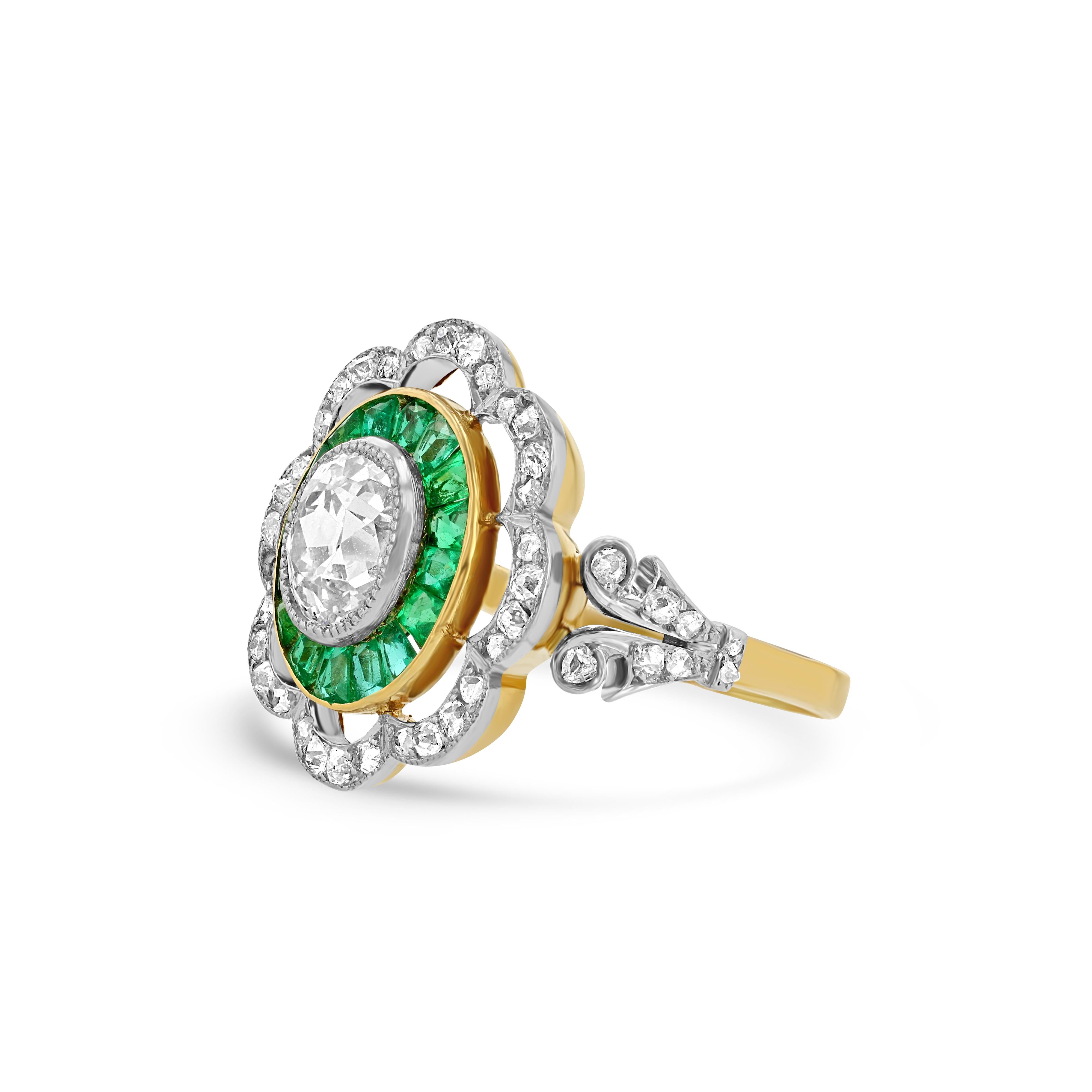This beautiful antique ring contains:

0.80 Carat Oval Old Mine Cut centered Diamond

Calibrated Emeralds

Outer ring of rose cut diamonds

18K Gold