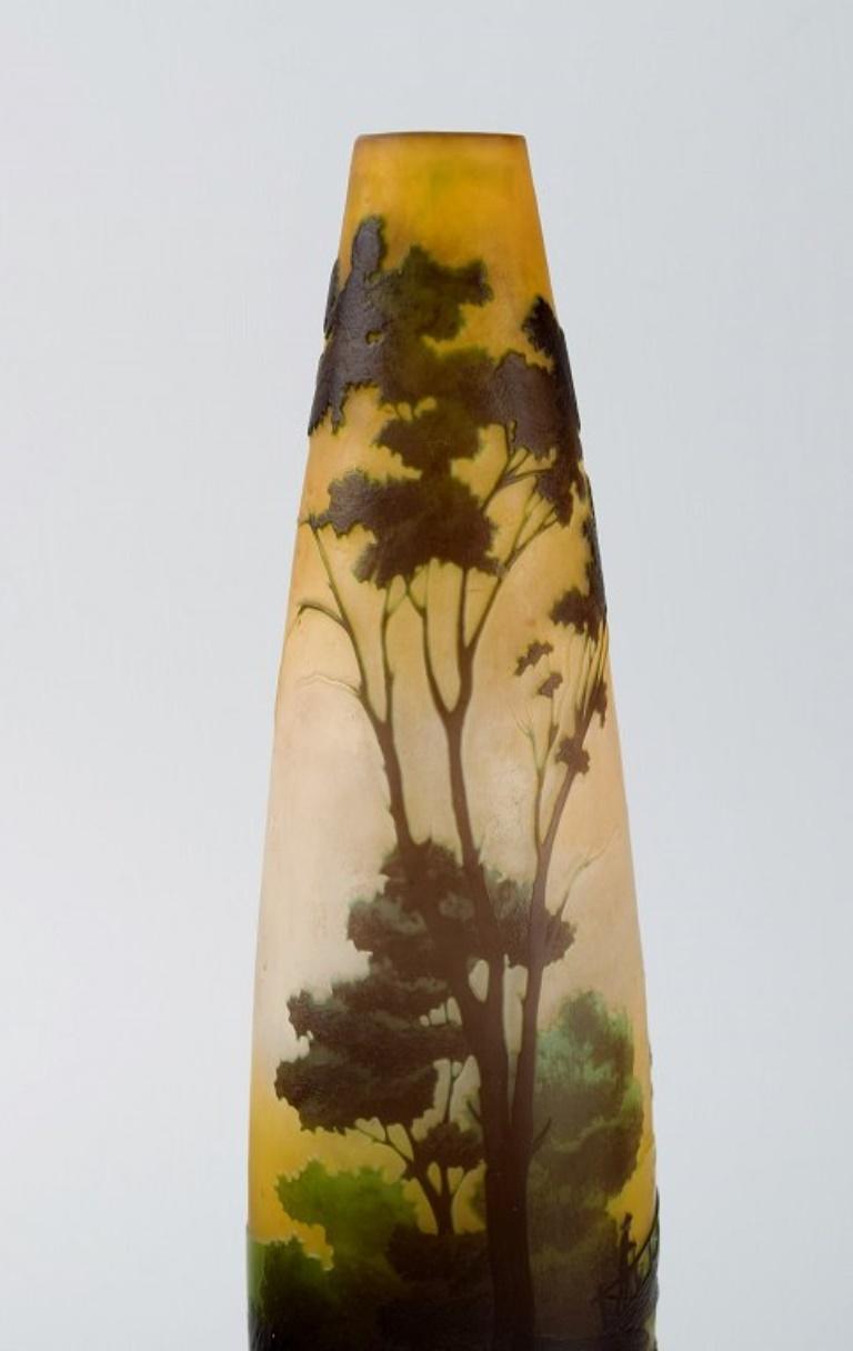 Antique Emile Gallé vase in yellow frosted and dark art glass carved in the form of a park landscape with trees and a bridge. 
Rare model. 
Early 20th century.
Measures: 27.5 x 7.7 cm.
In excellent condition.
Signed.