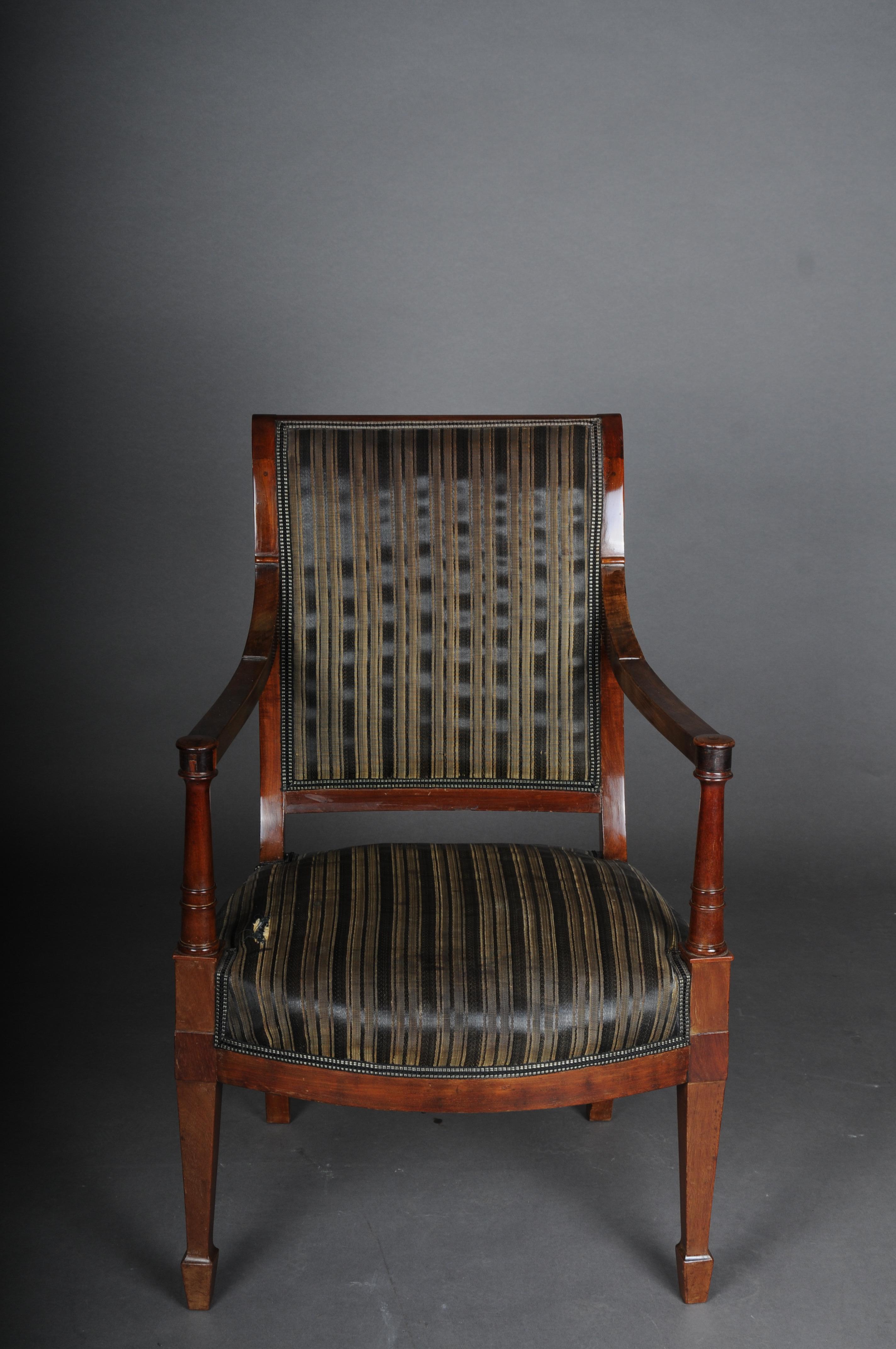 Antique Empire armchair, mahogany, around 1890.

Solid mahogany body. Back and seat upholstered and covered with a classic striped fabric cover.
Empire around 1890, France.
