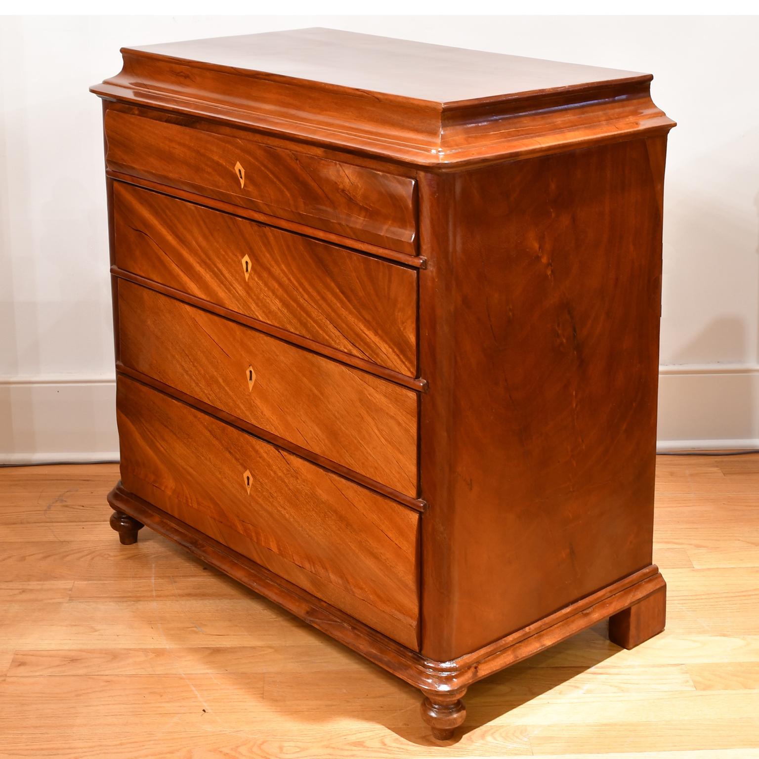 A beautiful Danish Empire or Biedermeier chest in fine West Indies mahogany with four drawers of staggered heights. The handsome figuring of the grain is given added movement by the flat cut contiguous veneer moving horizontally across the front of