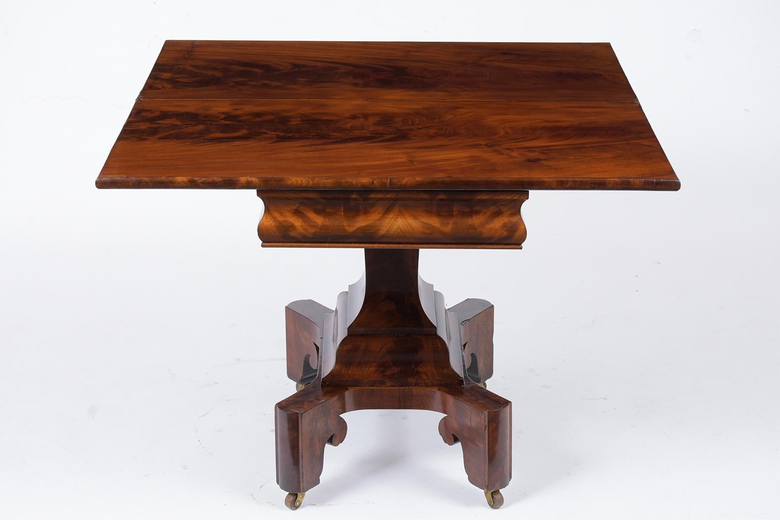 This French Late 19th-Century Empire Card Table has been restored and is made out of solid oak wood covered in Flemish mahogany veneers with a newly waxed patina finish. The top opens to set up as a game table, has an interior space for storage, and