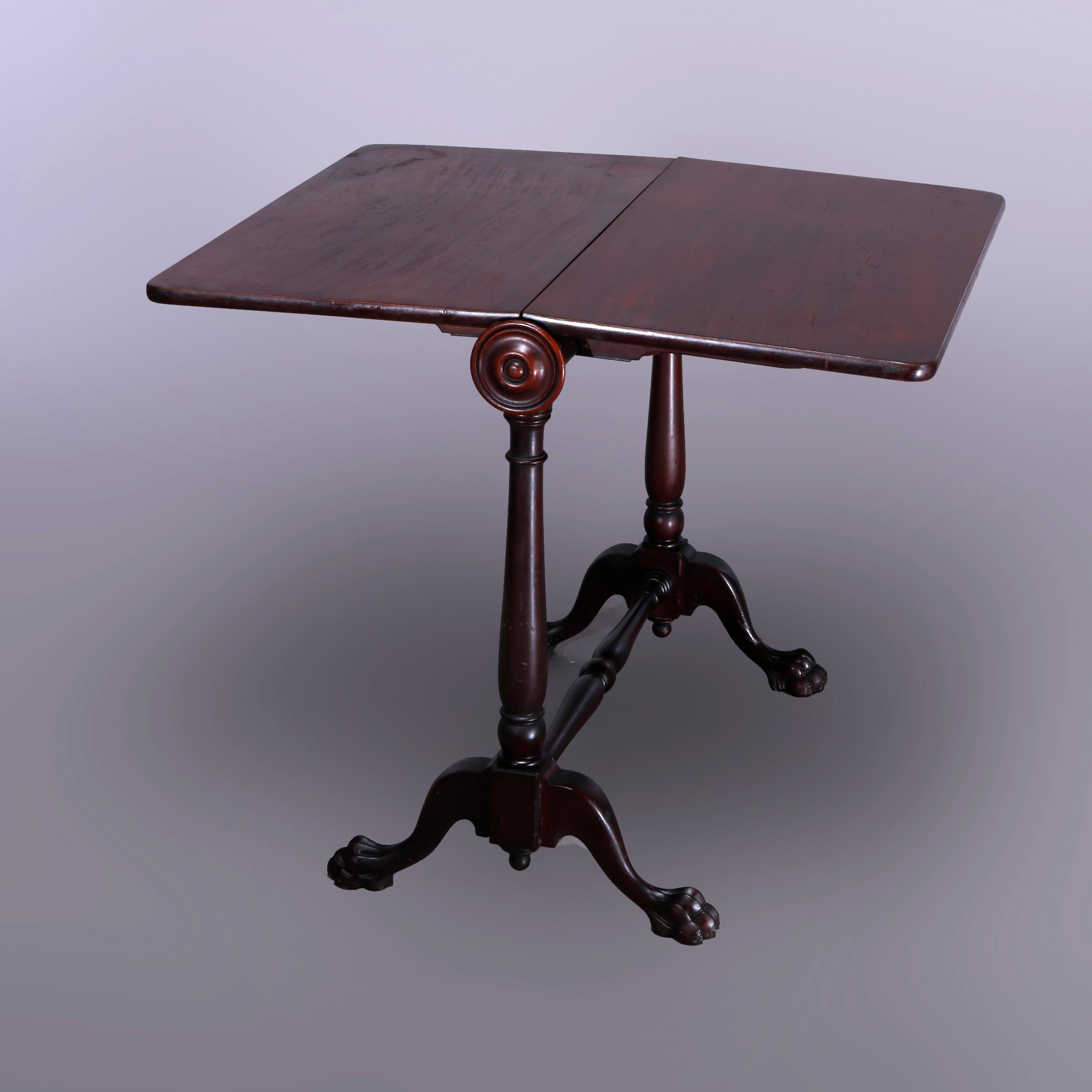 An antique American Empire napkin fold table offers mahogany construction with drop leaf top over trestle base having turned supports and raised on cabriole legs with carved paw feet, c1890

Measures- 29.5'' H x 33.25'' W x 18'' D.