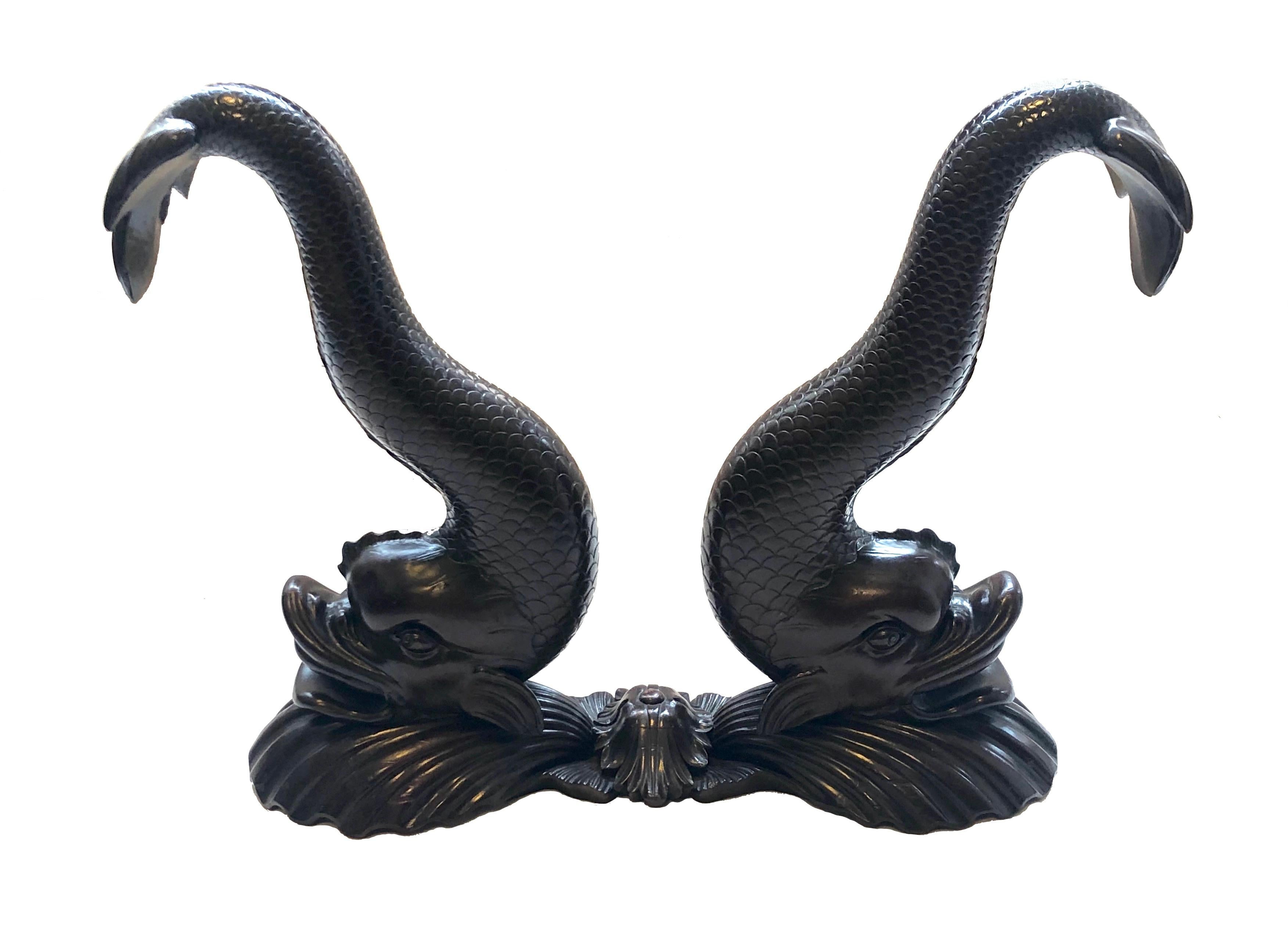 Two pairs of rare Empire carved dolphins are carved out of solid mahogany. They Stand on bases designed as scallops. They were made in Paris circa 1810.