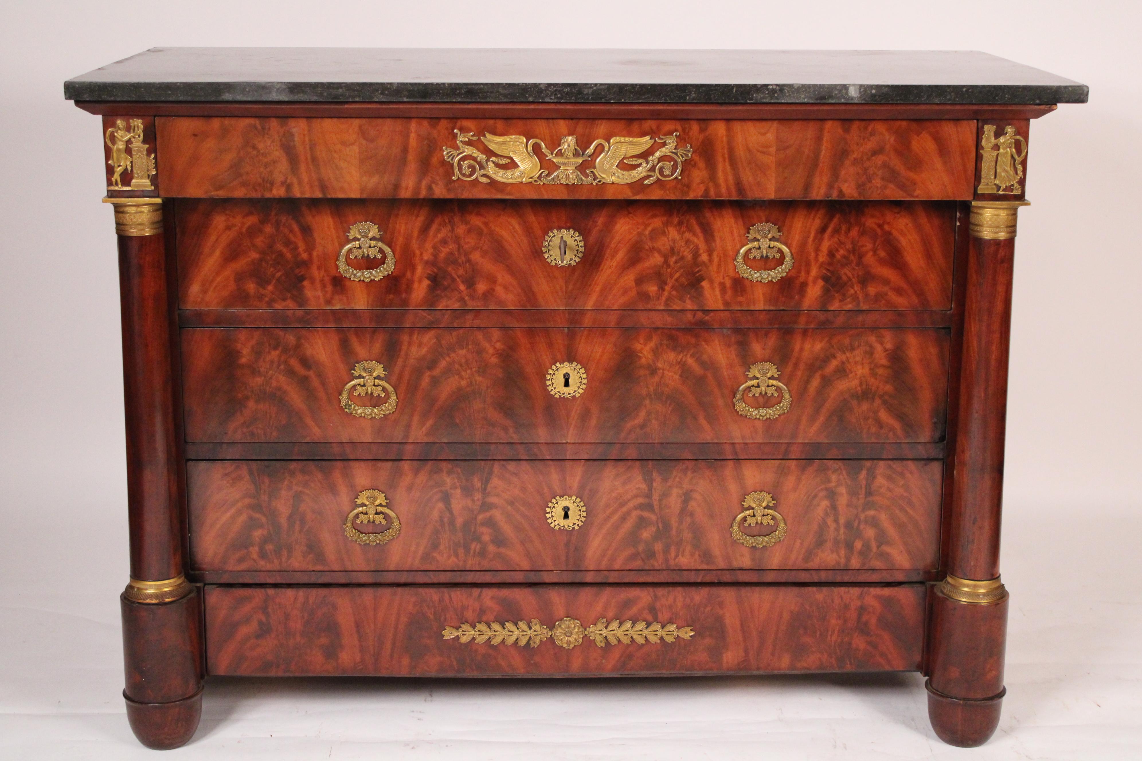 Antique Empire flame mahogany chest of drawers with gilt bronze mounts and marble top, early 19th century. With a rectangular marble top, the top drawer with a central gilt bronze mount of swans drinking from a fountain,  flanked by gilt bronze