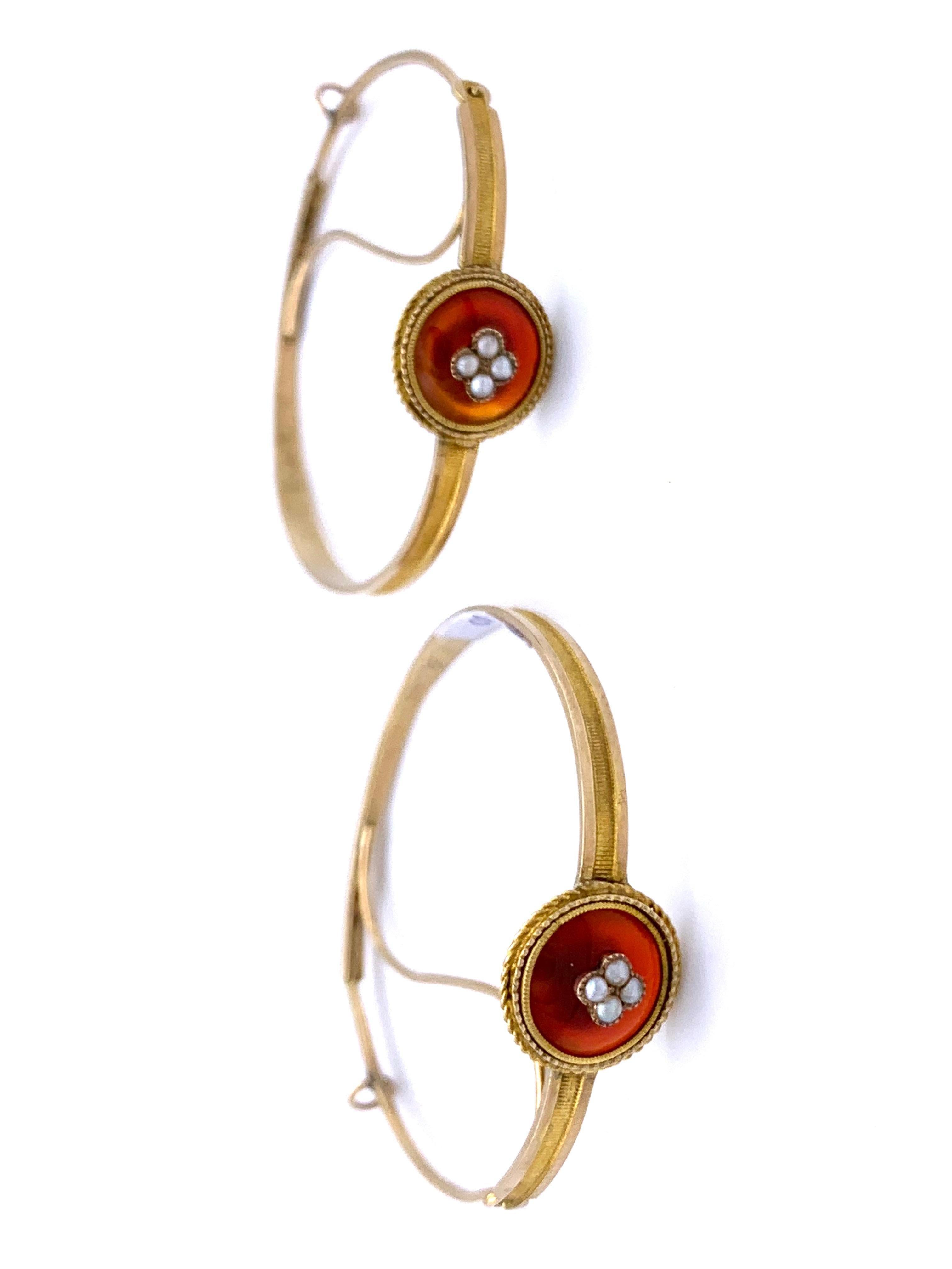 These very rare Empire gold hoop earrings were handcrafted out of 14 karat . The hoops are decorated with fine engraved lines. Each hoop is embellished  with a carnelian cabochon mounted in setting with a twisted gold wire surround. The two