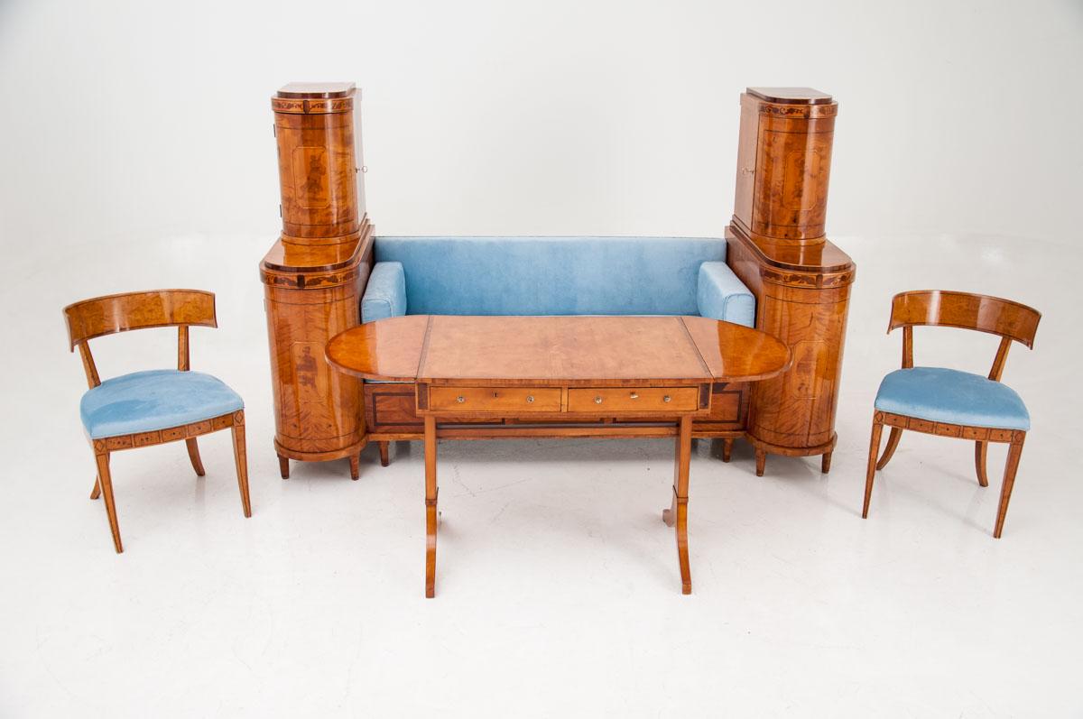 The antique salon set in the Empire style was created in the mid-nineteenth century from birch wood . Sofa's railing has a rather simple form, but it is remarkable with semi-circular commodes on the sides and with beautiful inlays. The seat and