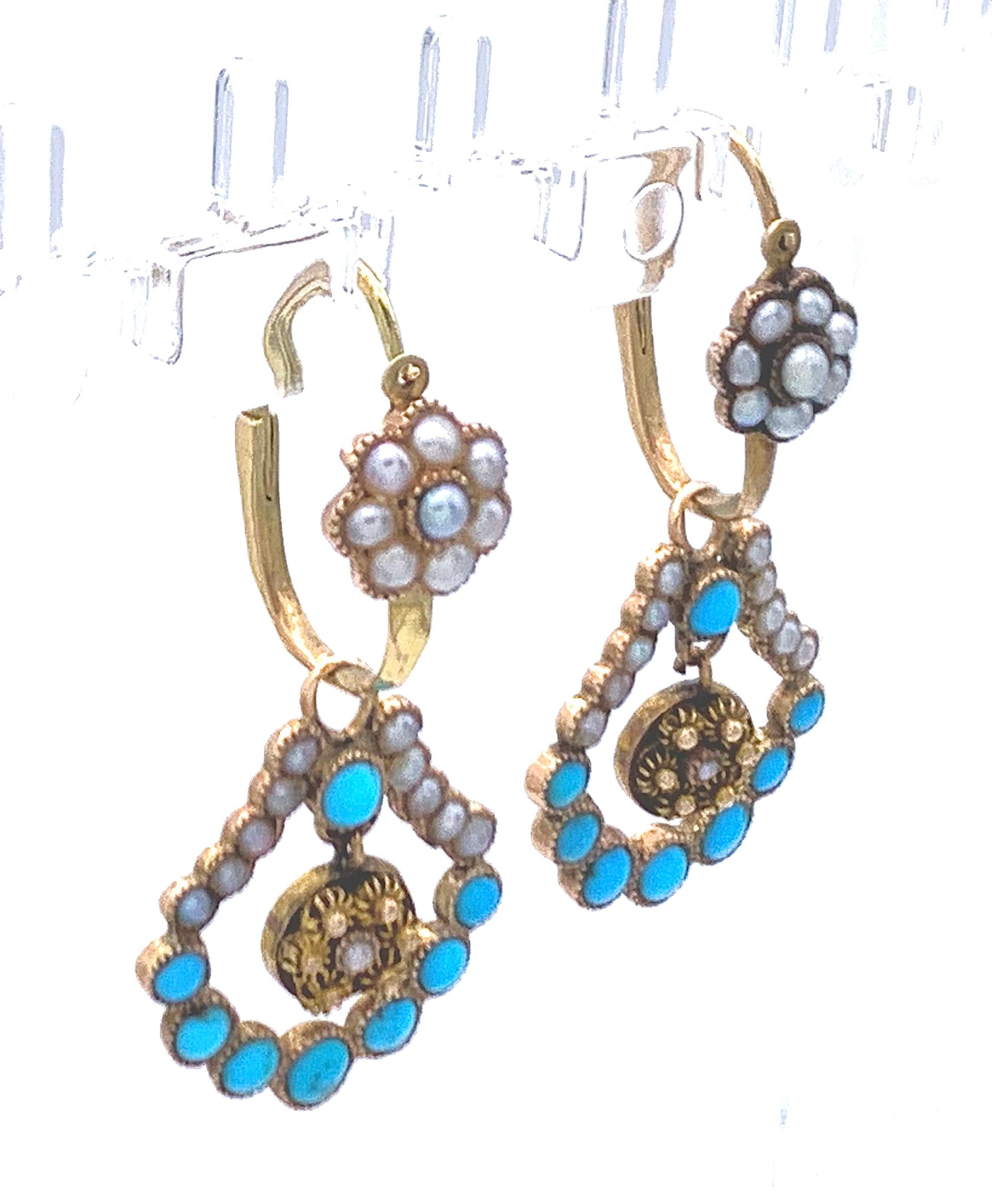 This is a fine example of delicate empire earrings, so called day and night earrings, the tops can be worn alone.
Small gold rosettes, oriental pearls and turqoise cabochons are fashioned  to make up these pretty
earrings. The dangling elements are