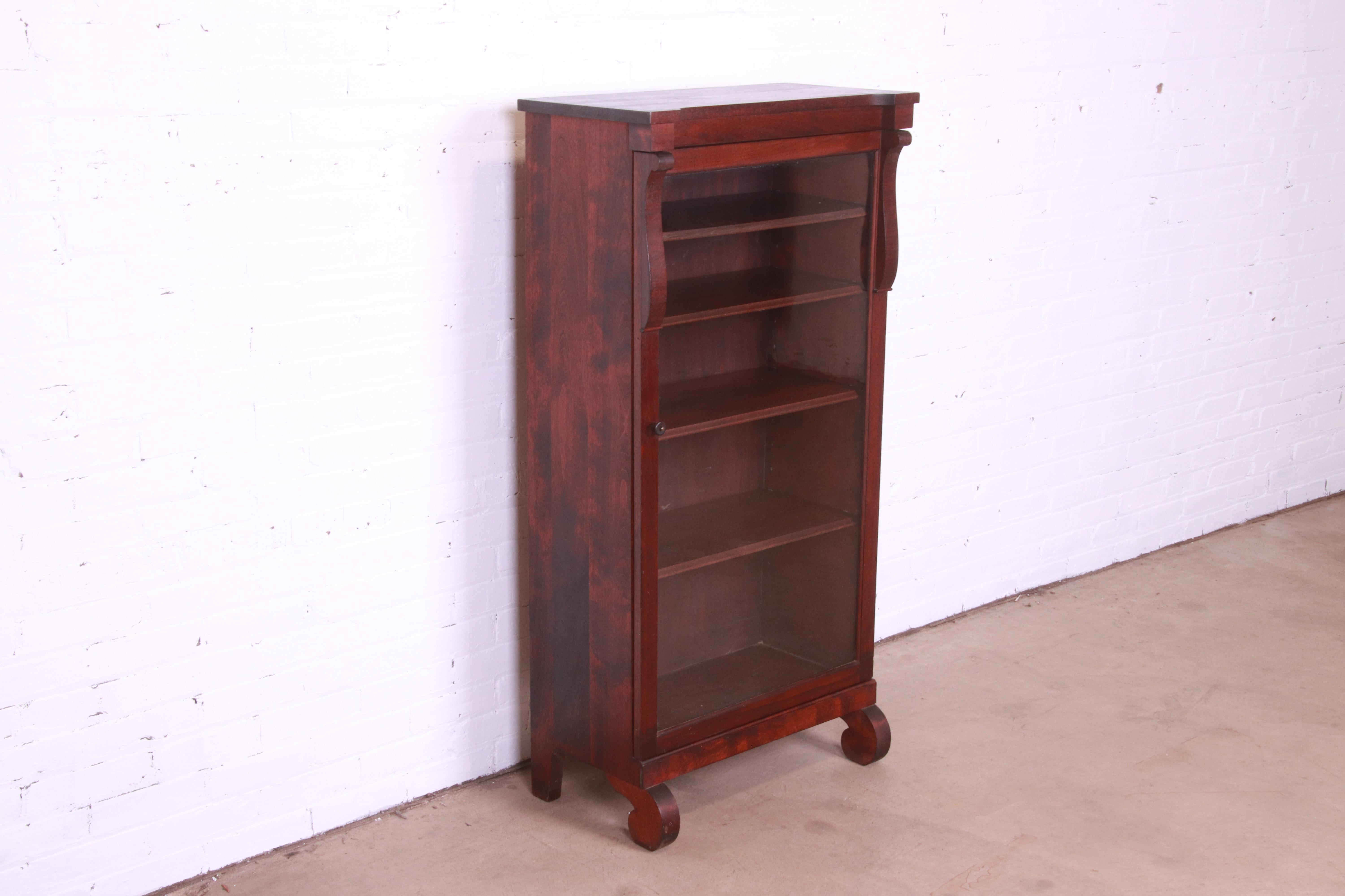 A beautiful antique Empire glass front bookcase cabinet

By Gimbel Brothers

USA, Circa 1900

Carved mahogany, with glass front door.

Measures: 26.25