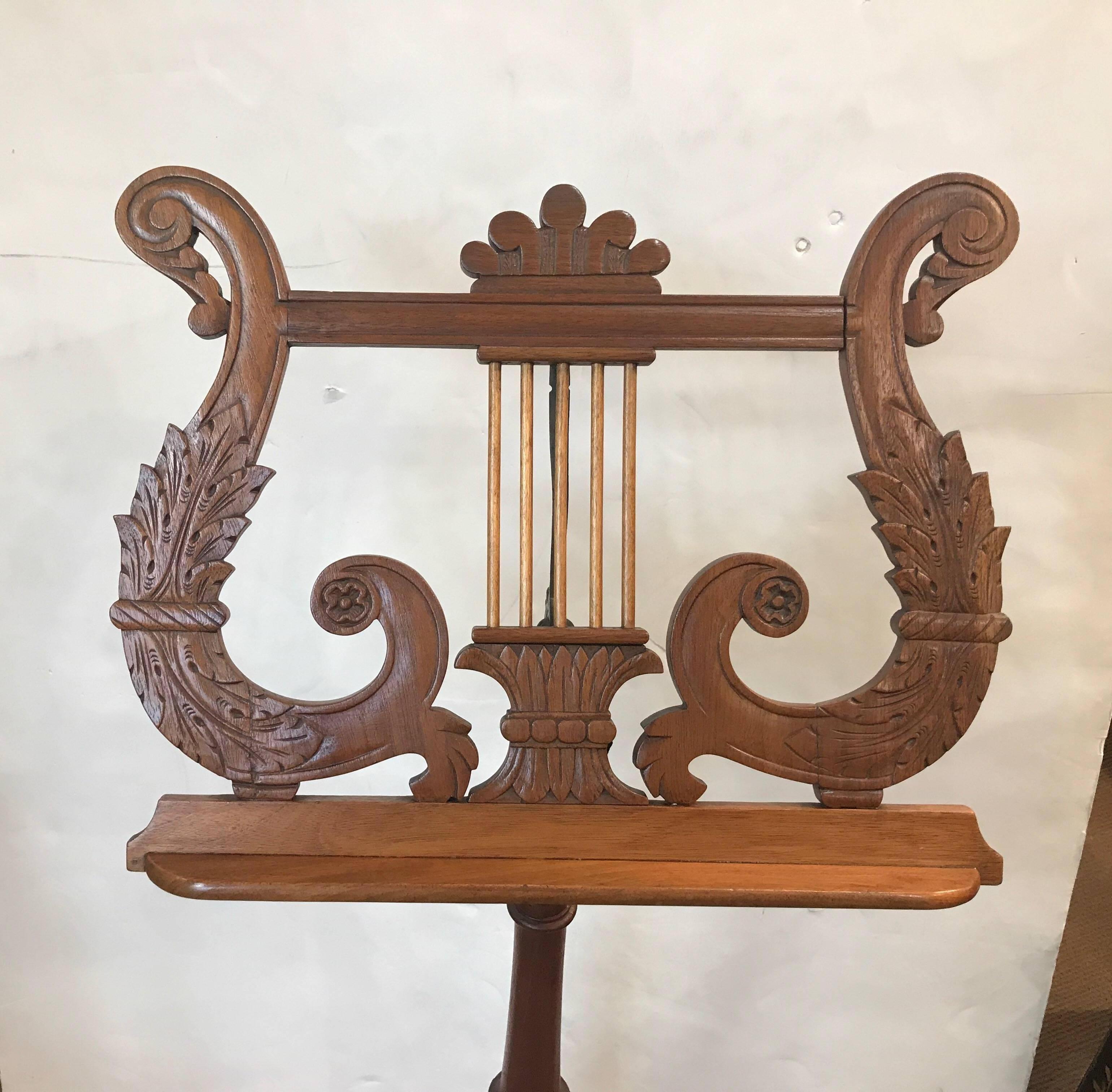 American Empire hand craved mahogany music stand. The carved surface with adjustable tilt of the music holder. The pole base with hand turned details supported by a carved tripod base.