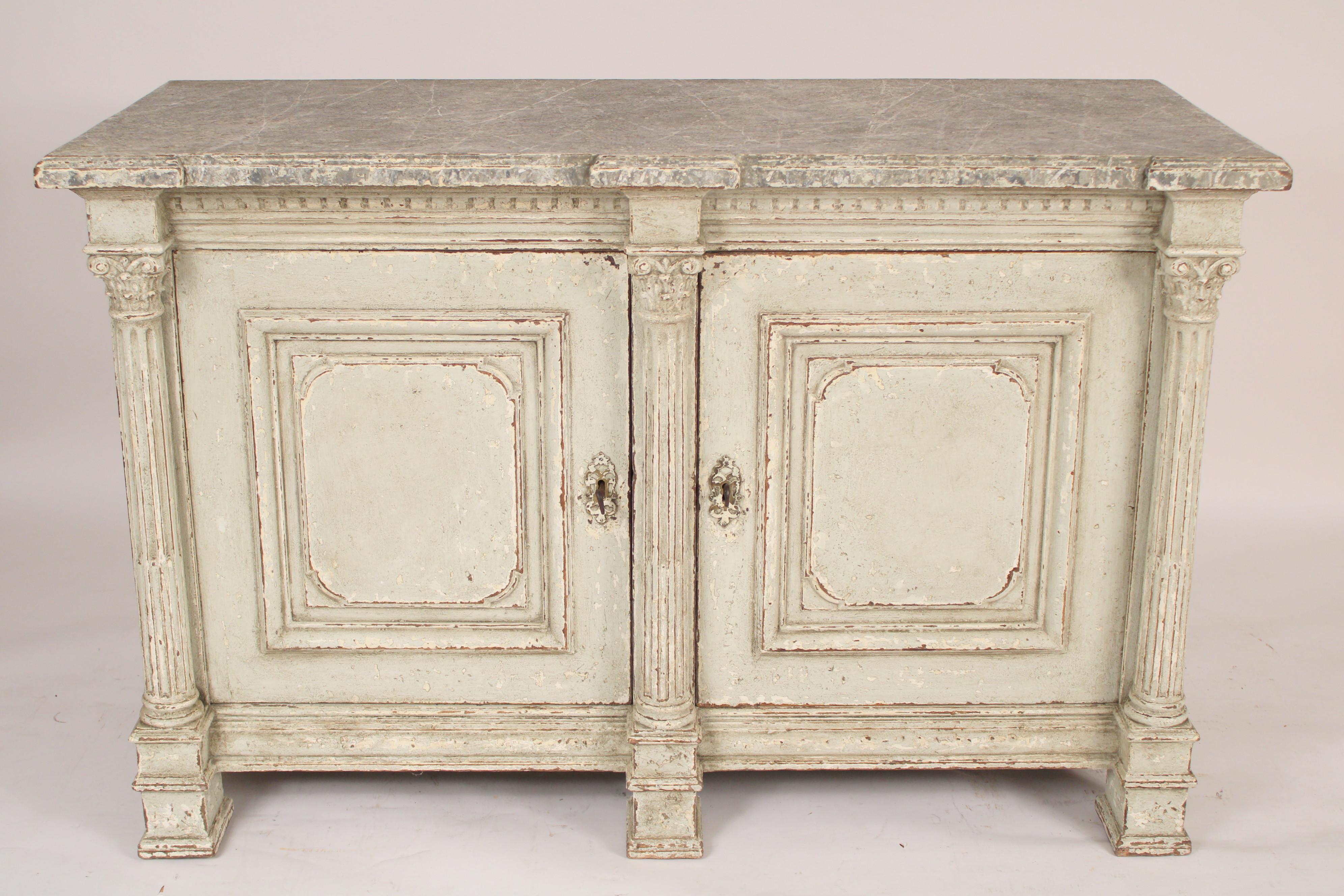 Antique Empire style painted buffet / cabinet, 19th century. The paint is later and 20th century. With a faux marble molded overhanging top over two cupboard doors separated and framed by 3 fluted columns with corinthian capitals, a stepped apron