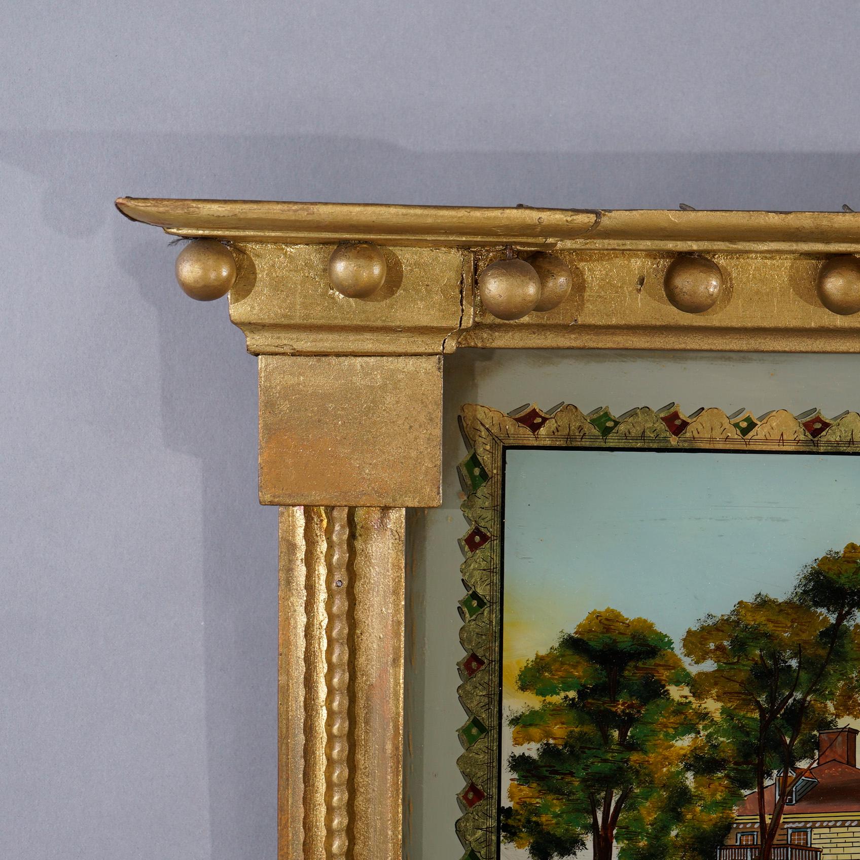 An antique American Empire Trumeau wall mirror offers giltwood frame with upper having reverse painted estate scene, 19th century.

Measures - 31''H x 18''W x 3.5''D.

Catalogue Note: Ask about DISCOUNTED DELIVERY RATES available to most regions