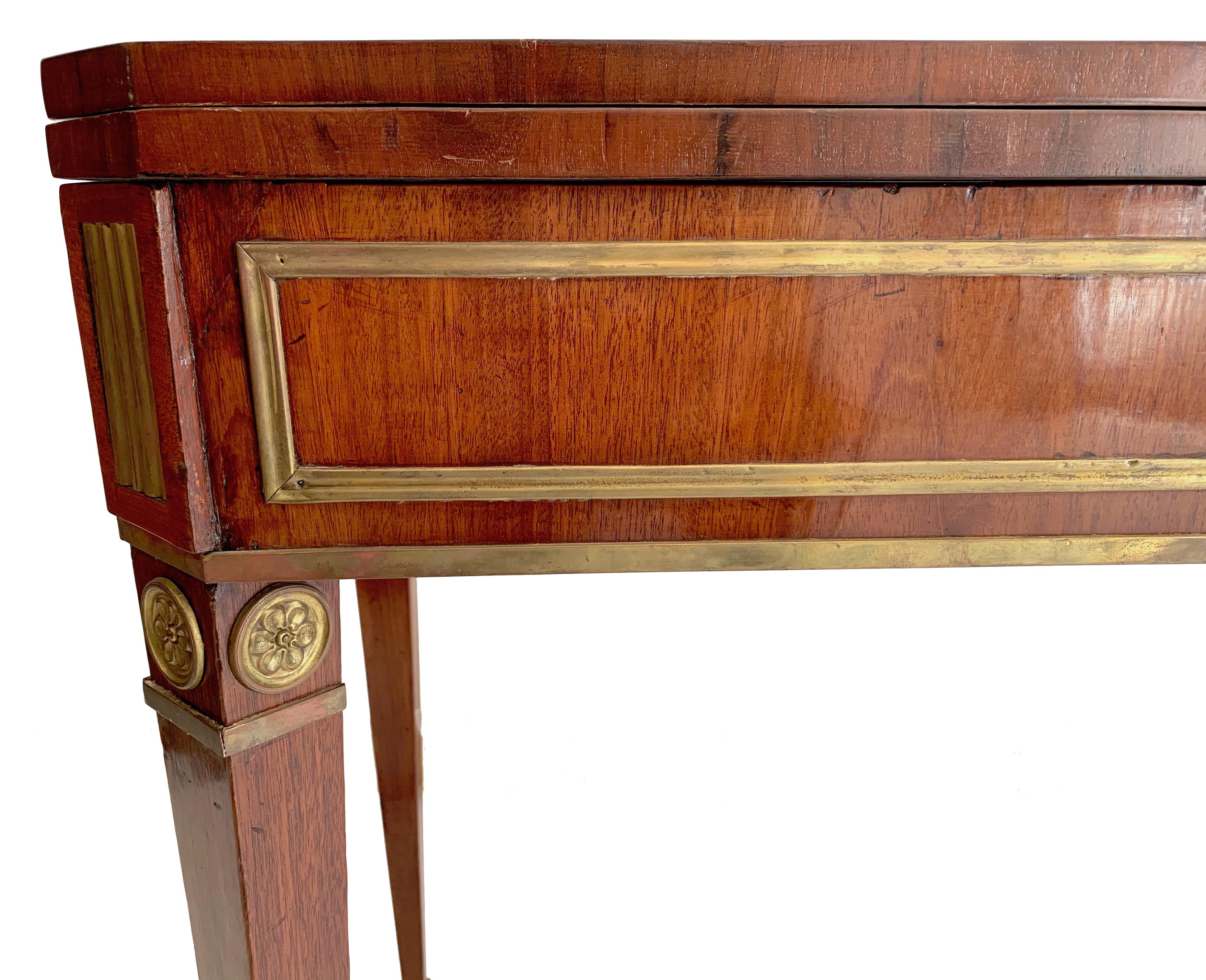 This elegant Russian games and console table was made in st Petersburg circa 1810. It has ben crafted out of mahogany and is decorated with fine brass banding.The table is convertible into a console, then it measures 92 cm in width and 46 cm in