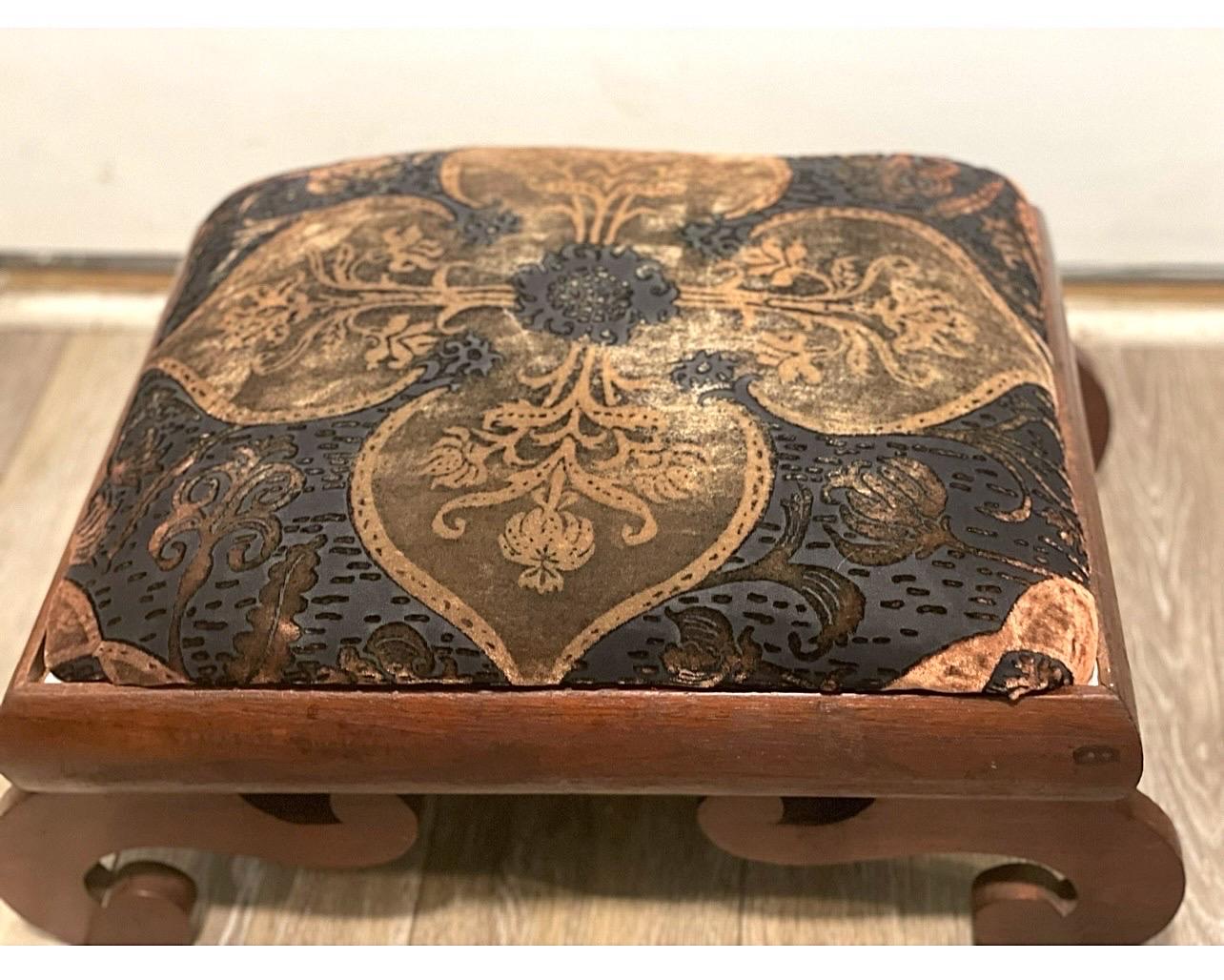 A beautiful mahogany footstool with beautiful exaggerated scroll legs.   New old stock velvet burnout upholstery has been added.  C. 1890