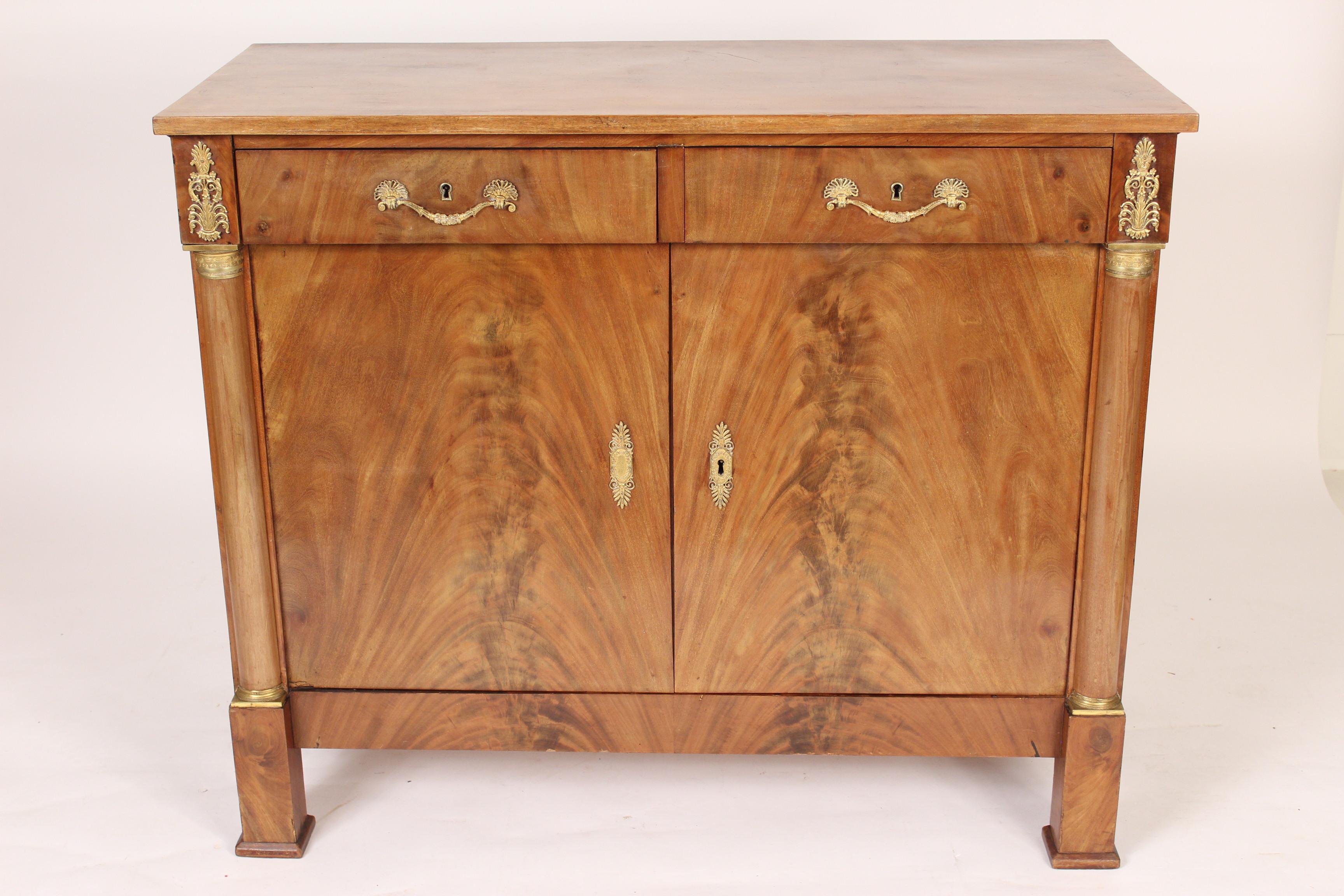 Antique Empire style mahogany buffet, late 19th century. With flame mahogany doors, gilt bronze hardware and hand dove tailed drawer construction.