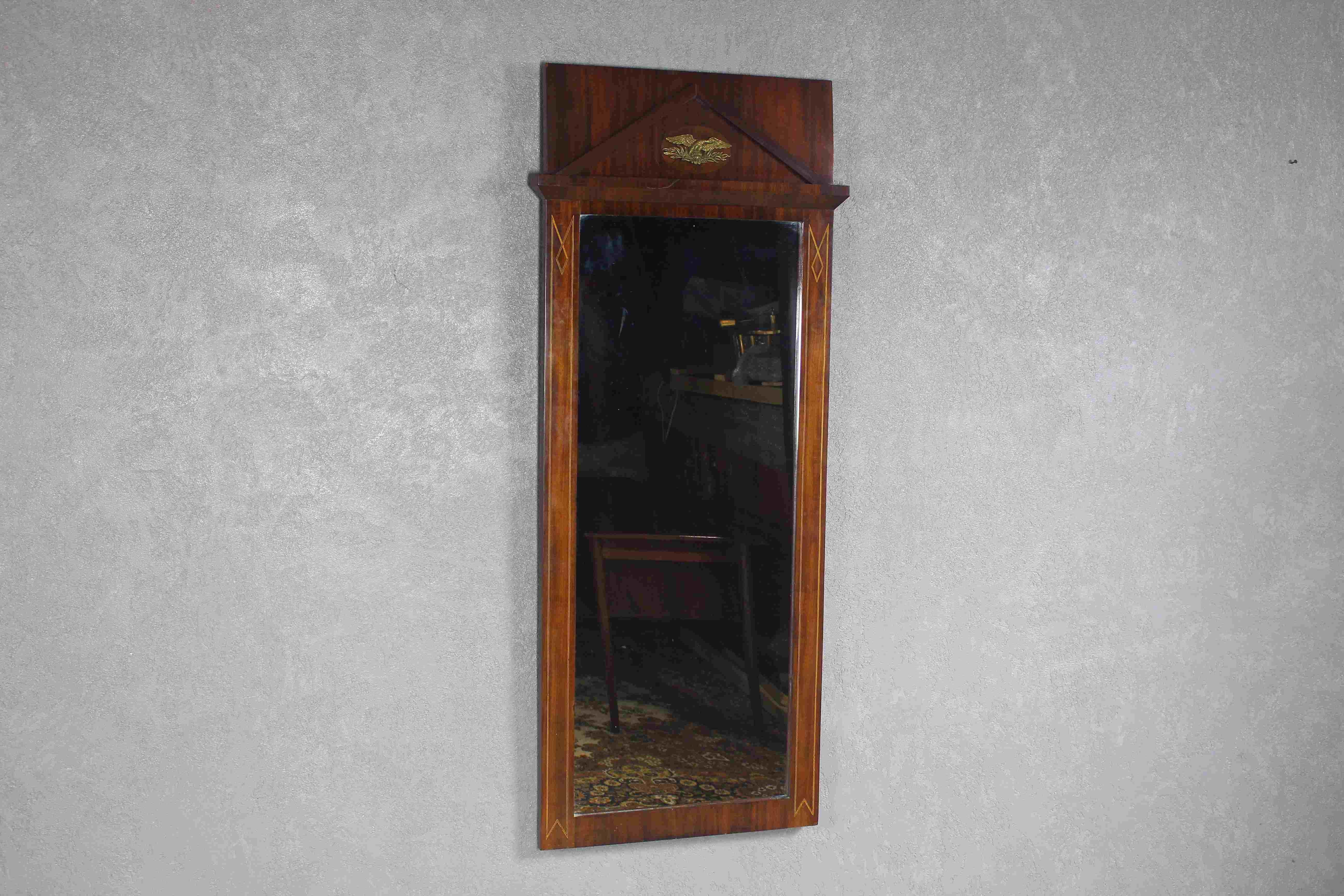Antique Empire style mirror from the end of the 19th century.
The Mirror of hand-polished mahogany is a beautifully crafted piece of furniture that was made in Denmark during the late Empire period.