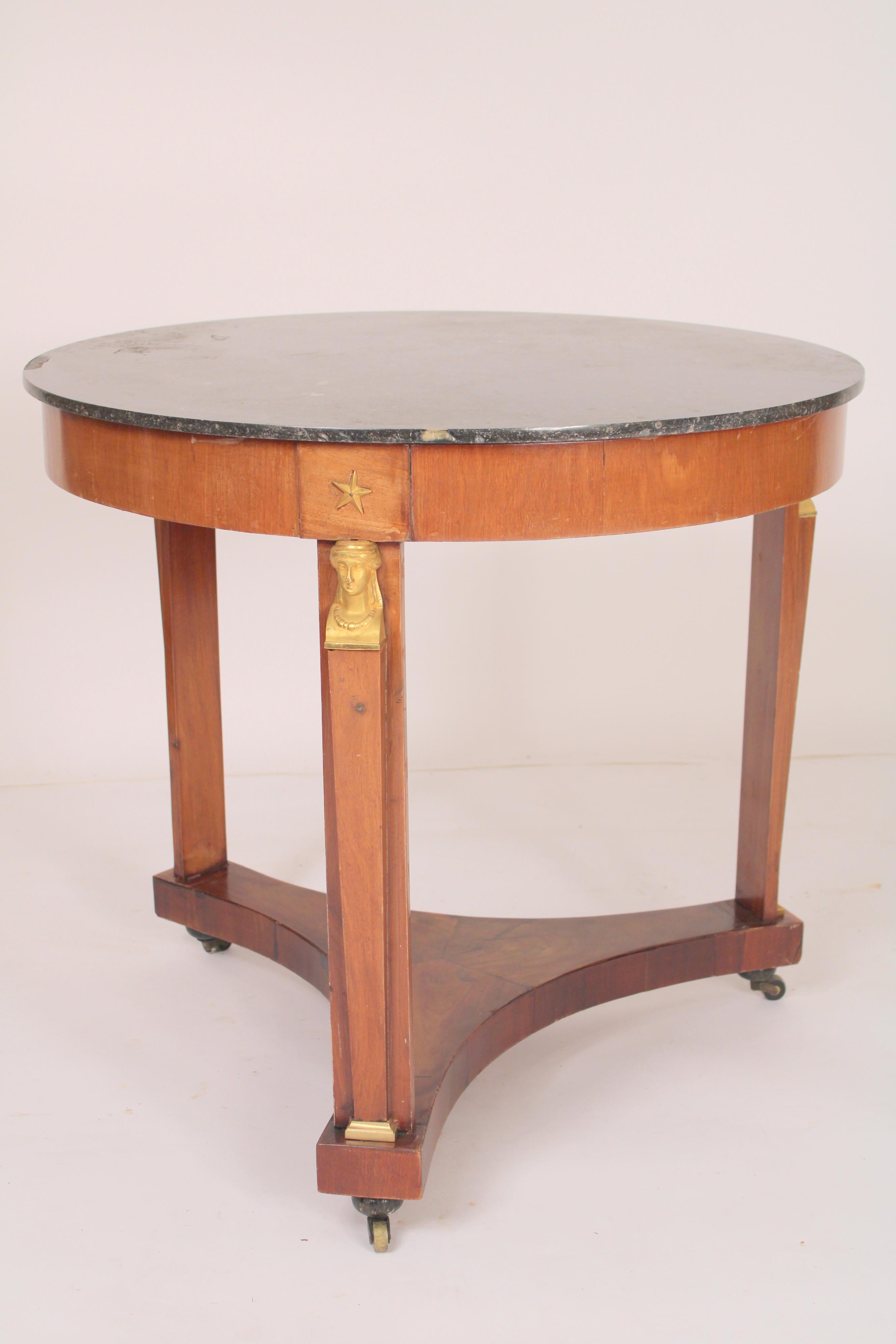 Antique Empire style mahogany side / center table with gilt bronze mounts and a marble top, circa 1900.