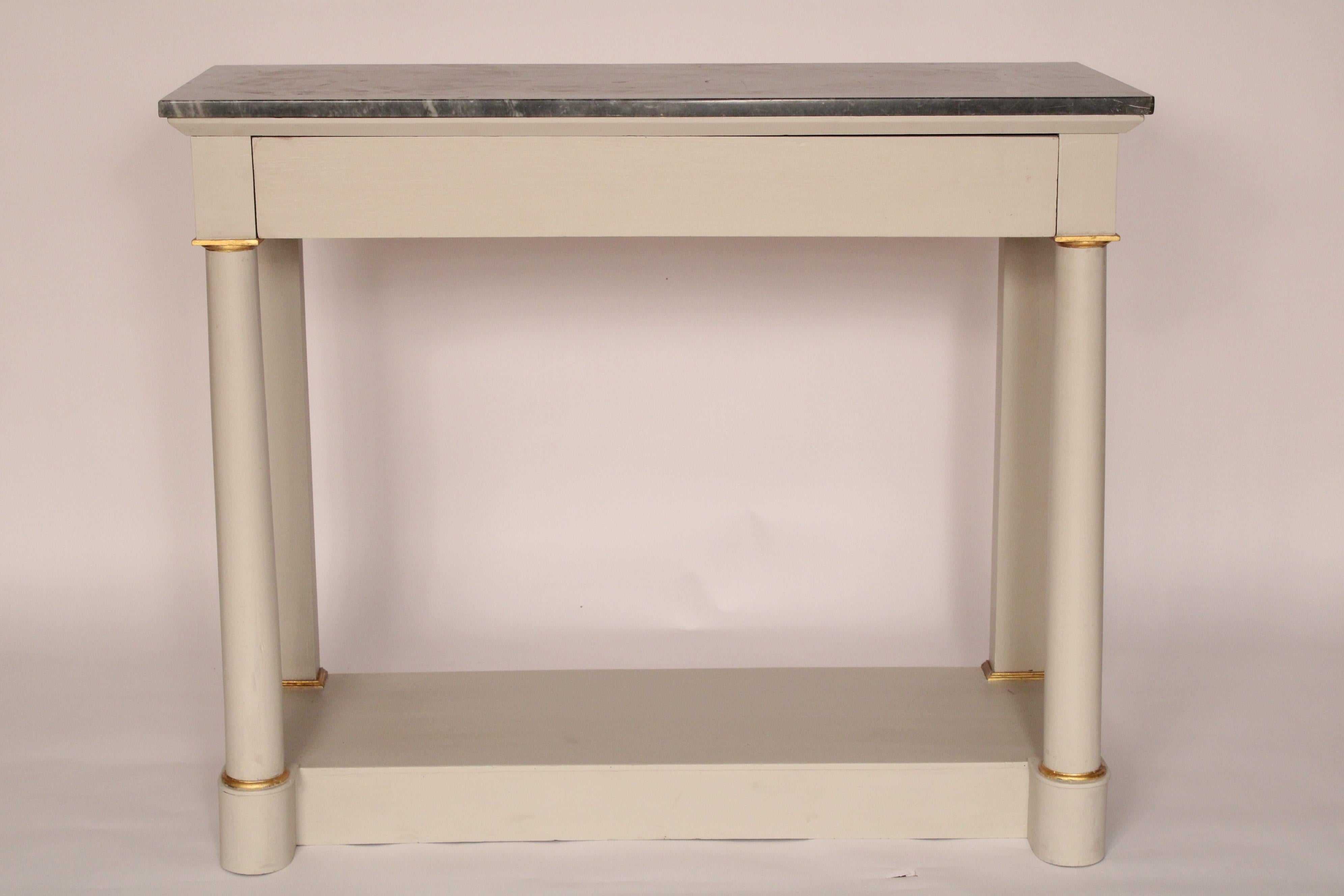 Antique Empire Style painted marble top console table, circa 1900. The paint is later. With a rectangular marble top, a frieze drawer, two columns with gilt highlights, resting on a platform base. Hand dove tailed drawer and case construction.
