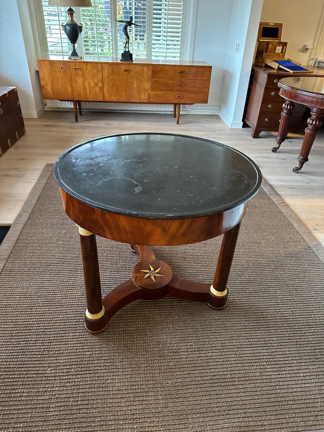 Antique empire table. Beautiful table with ormolu-plated column pedestals and natural stone top. The turned base has inlay work in the shape of a star. Completely in very good condition. Beautiful to use as a hall table or side table.

Origin: