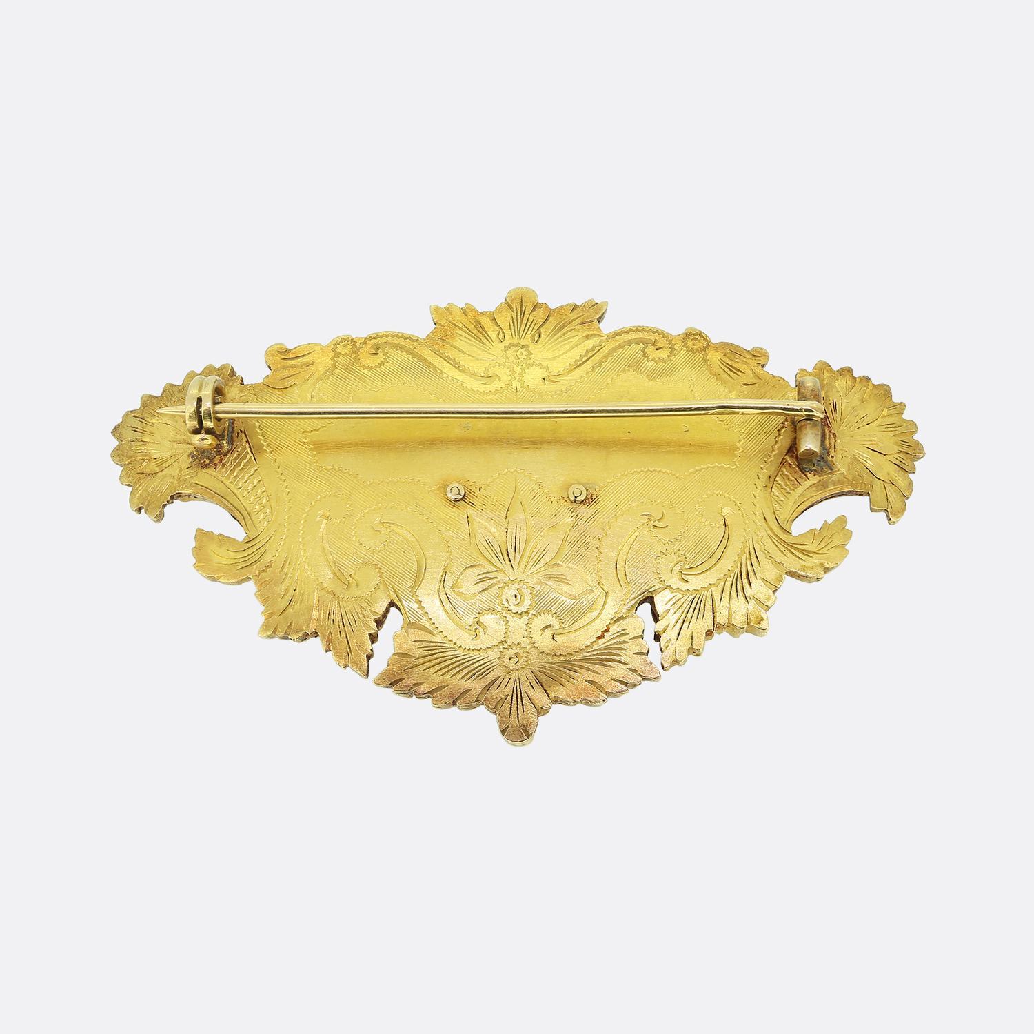 Here we have a charming enamel and diamond brooch taken from the Victorian period. This antique piece has been crafted from a rich 18ct yellow gold with an elaborately sculpted curvaceous design dominating the outer edge. This ornate frame plays