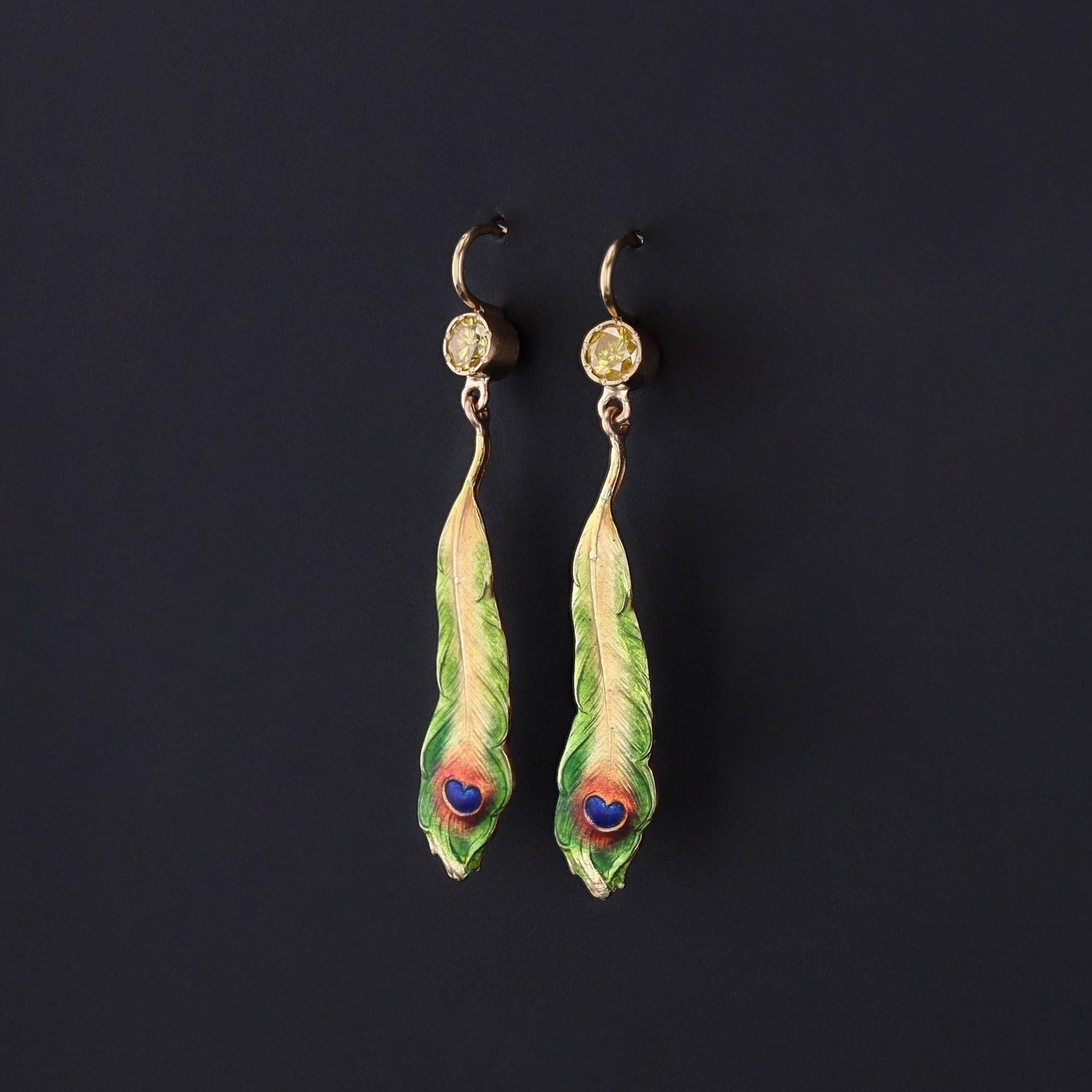 Peacock feathers represent immortality, and in some cultures, the eye-like design of the feather is believed to absorb negative energies. 

These earrings were created from antique pins (circa 1910) and feature peacock feathers of 14k gold, adorned