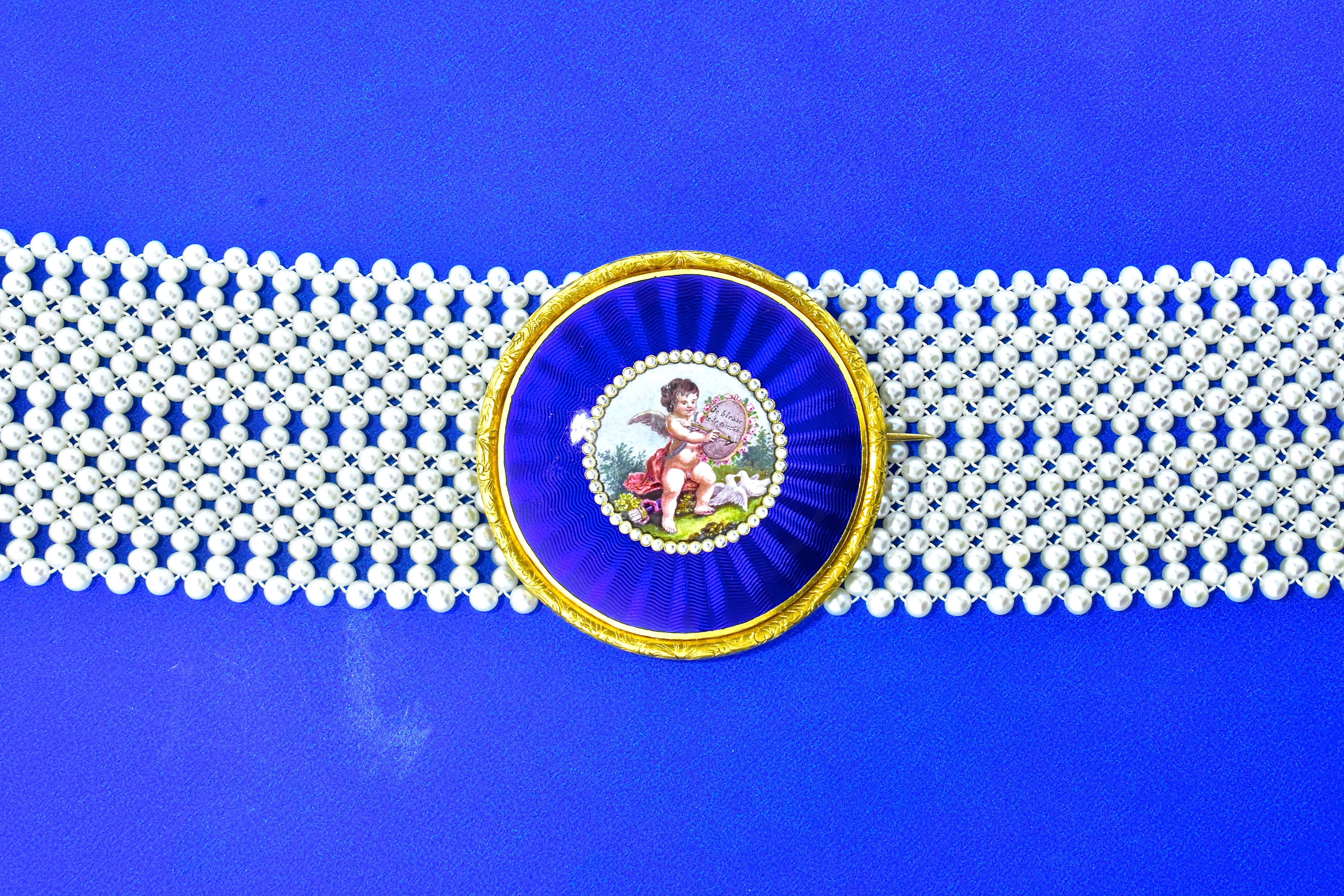 Antique brooch displaying a wonderful array of enameling.  It is pinned on a woven pearl contemporary dog collar which has a gold clasp.   It can be worn both as the center to this collar or removed and worn separately.  The woven pearl collar is