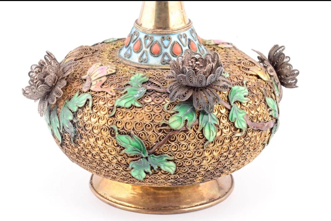 
This antique Chinese silver vase is a true masterpiece, adorned with intricate floral enamel workmanship that showcases the artistry of traditional Chinese craftsmanship. The vase's origin can be traced back to China, adding to its historical value