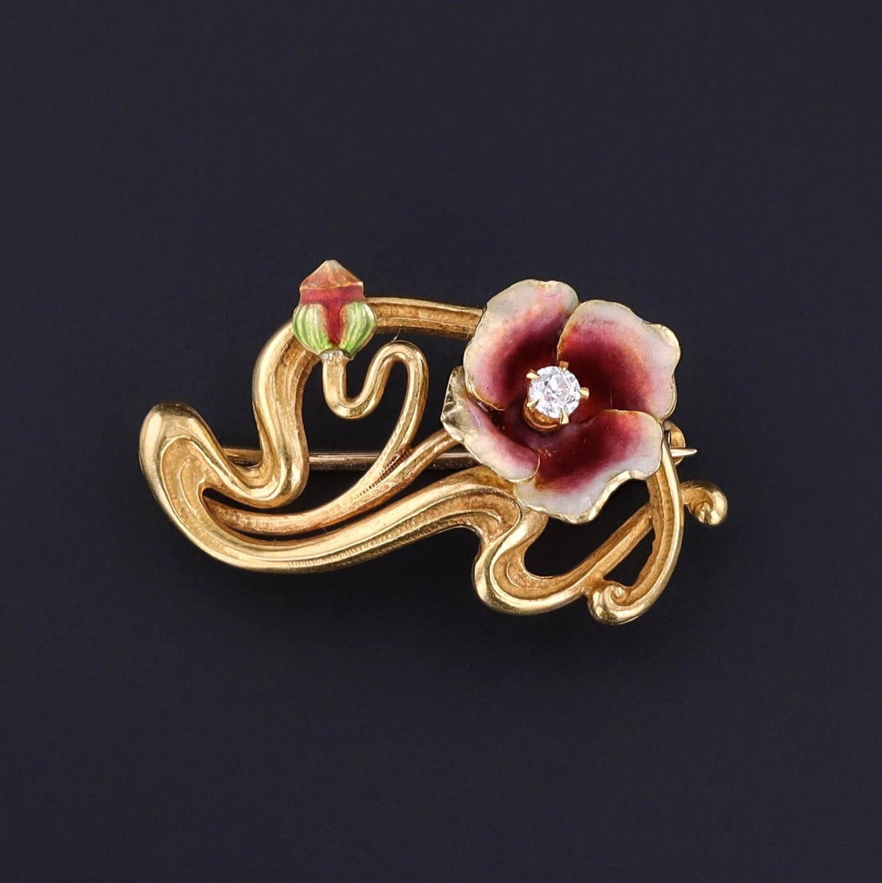 This 14k gold antique brooch (circa 1910) features a flower of dark pink and white enamel with a diamond accent. The reverse bears the makers mark for the renowned Krementz & Co of Newark New Jersey.

The piece measures 0.6 inches by 1 inch wide,