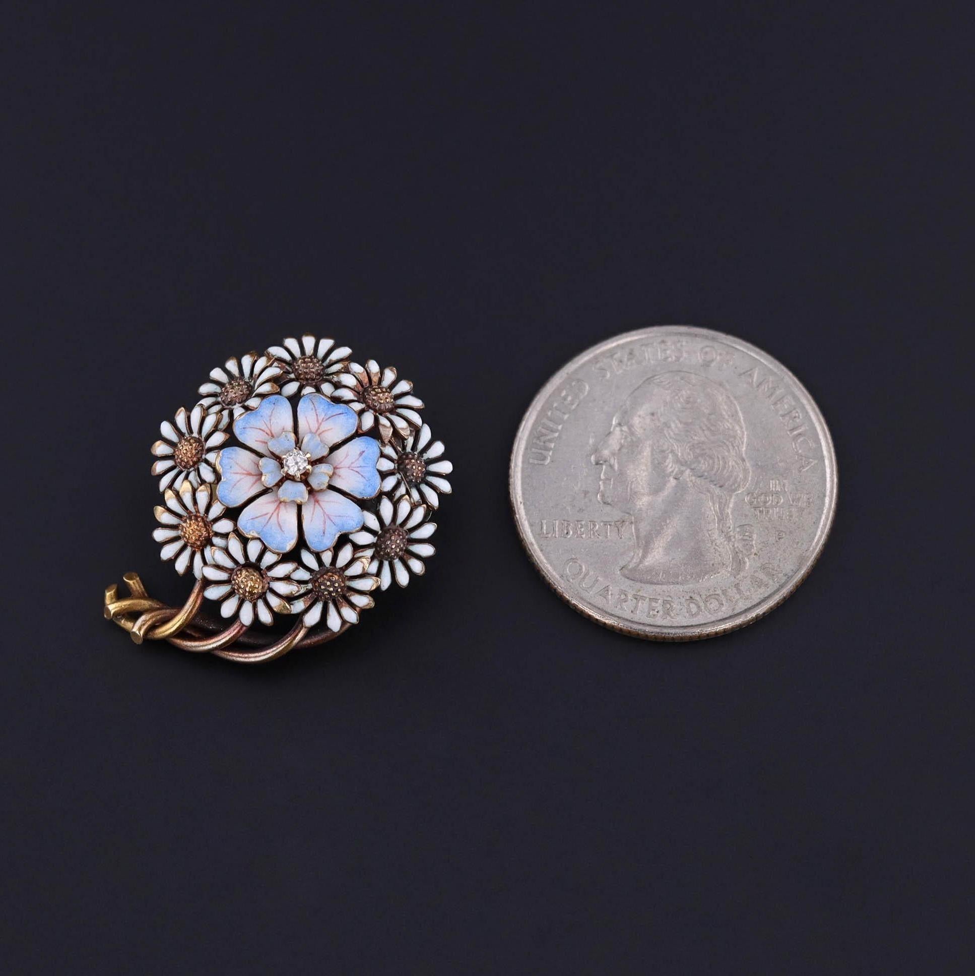Antique Enamel Flower Brooch: This antique brooch (circa 1900) features a blue enamel flower set in a halo of white enamel daisies. The brooch is 14k gold and accented by a single diamond.

The piece measures 1 inch by 0.9 inches wide and weighs 5.5
