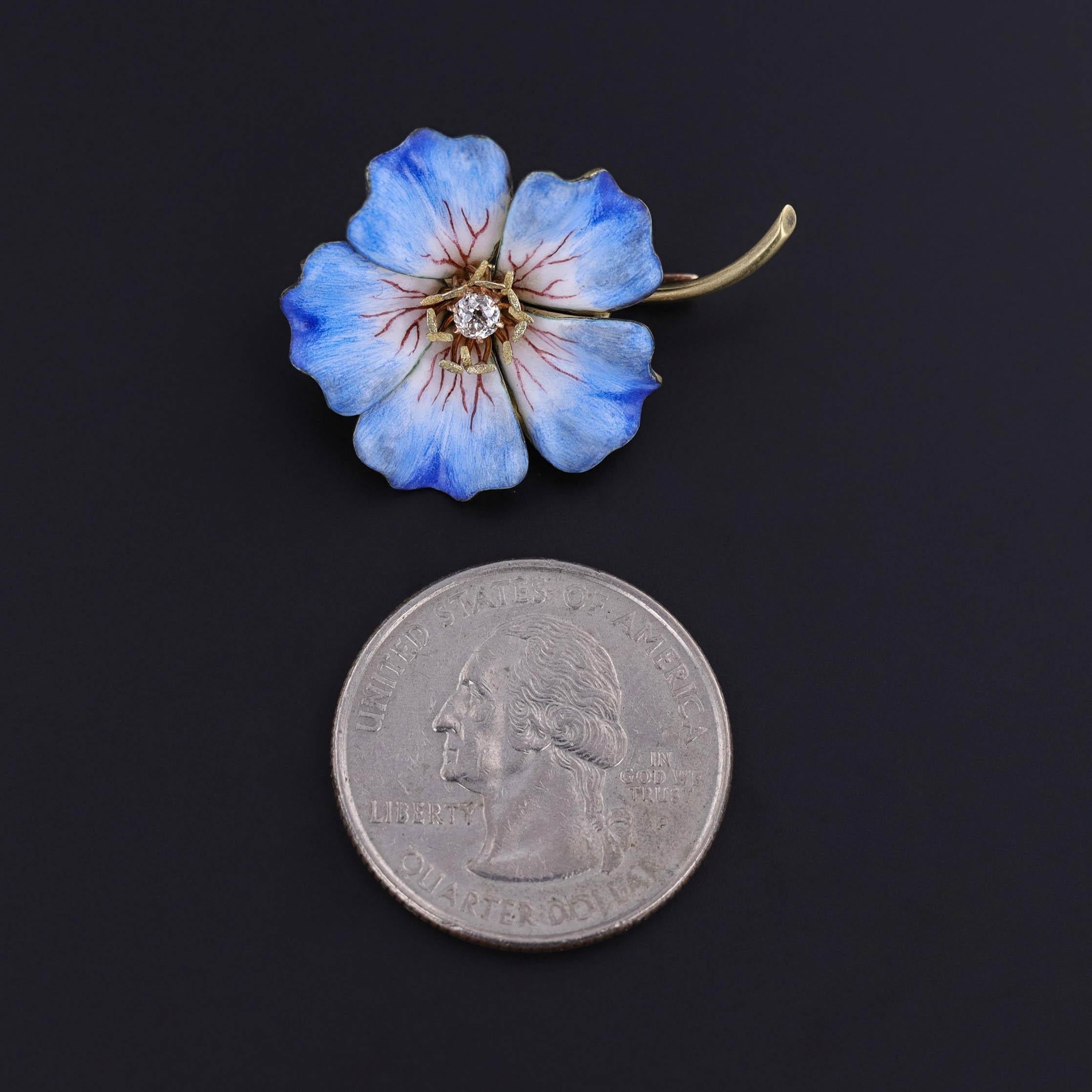 Eine antike Blumenbrosche aus 18-karätigem Gold mit blauem und weißem Email und einem einzelnen Diamanten im Minenschliff in der Mitte.

Das Stück misst 0,9 Zoll mal 1,25 Zoll und wiegt 6,25 Gramm. Es ist in sehr gutem Zustand.

Der Metallgehalt
