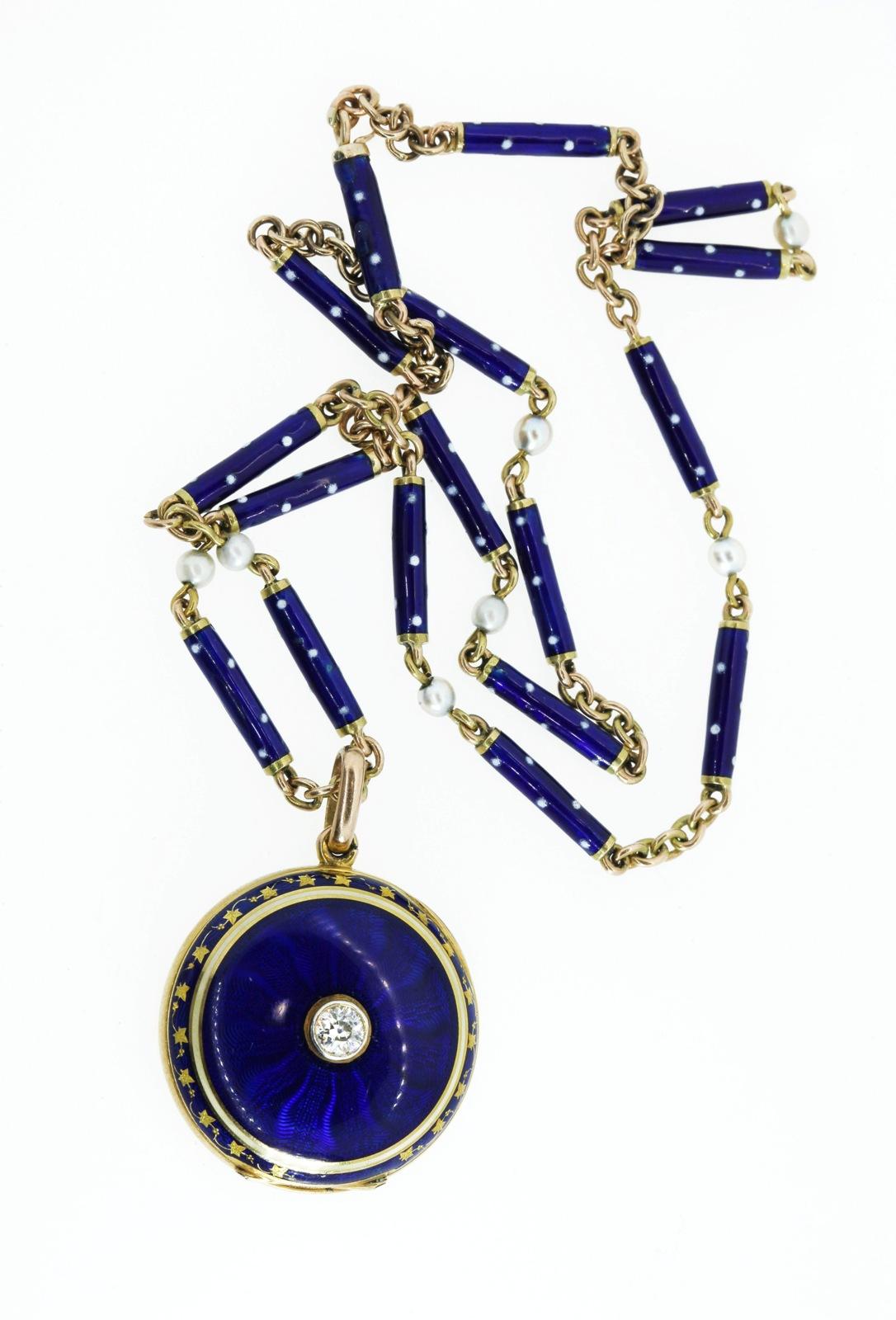 This unusual circa 1910 18KT yellow gold pendant centers an Old European Cut Diamond of approx. 0.28 carat set in a platinum bezel and surrounded by deep Royal blue guilloche enamel.  A circle of creme enamel is completed by a border of blue enamel