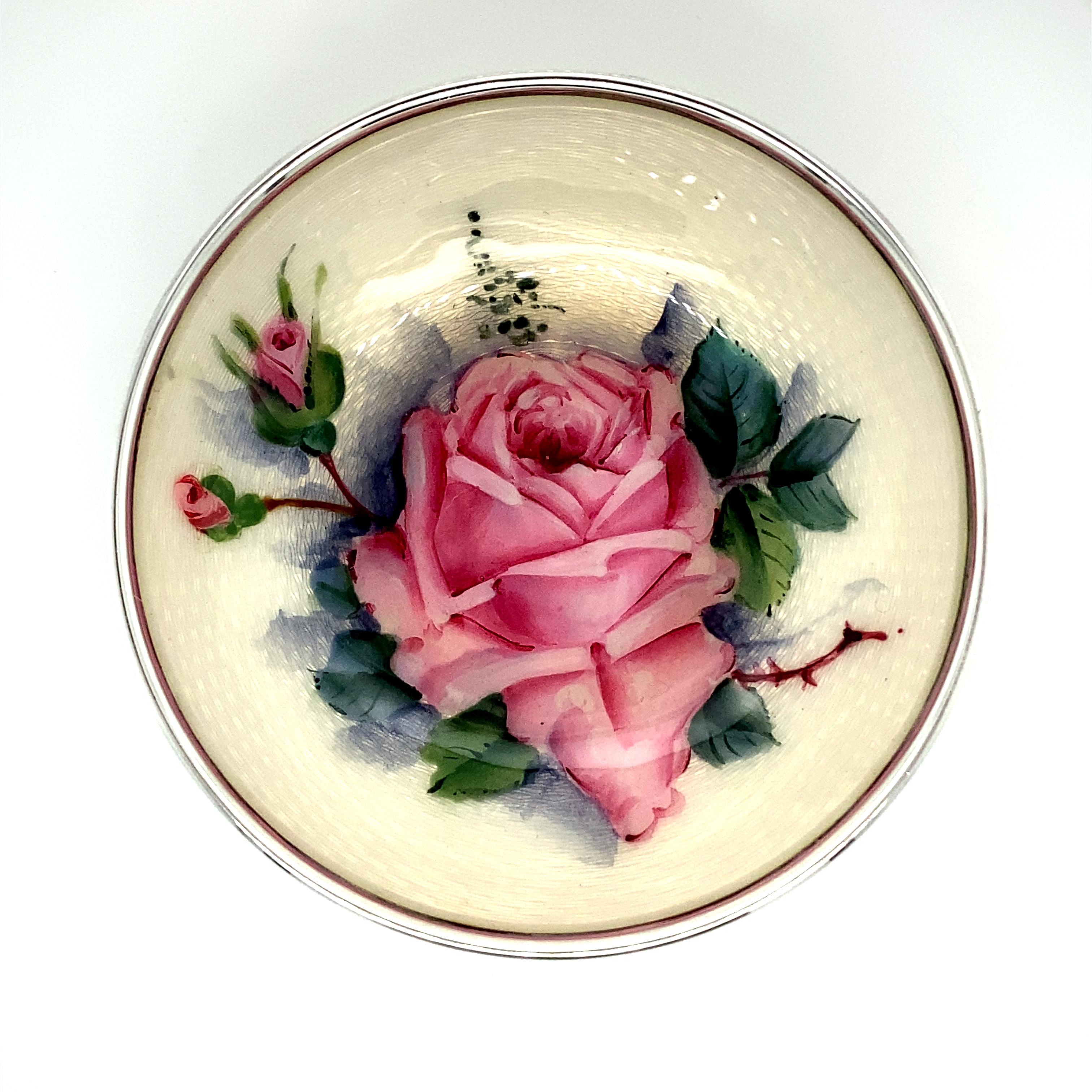 Gorgeous enamel and sterling silver round dish.  A luminous depiction of an enchanting rose with rose buds and leaves in the foreground and an enameled basketweave pattern background.  The colors range from pink, green, gray-blue and cream.  Perfect