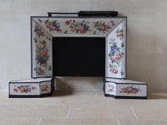 Antique enameled fireplace insert with floral motif and scallop handle, c. 1900
