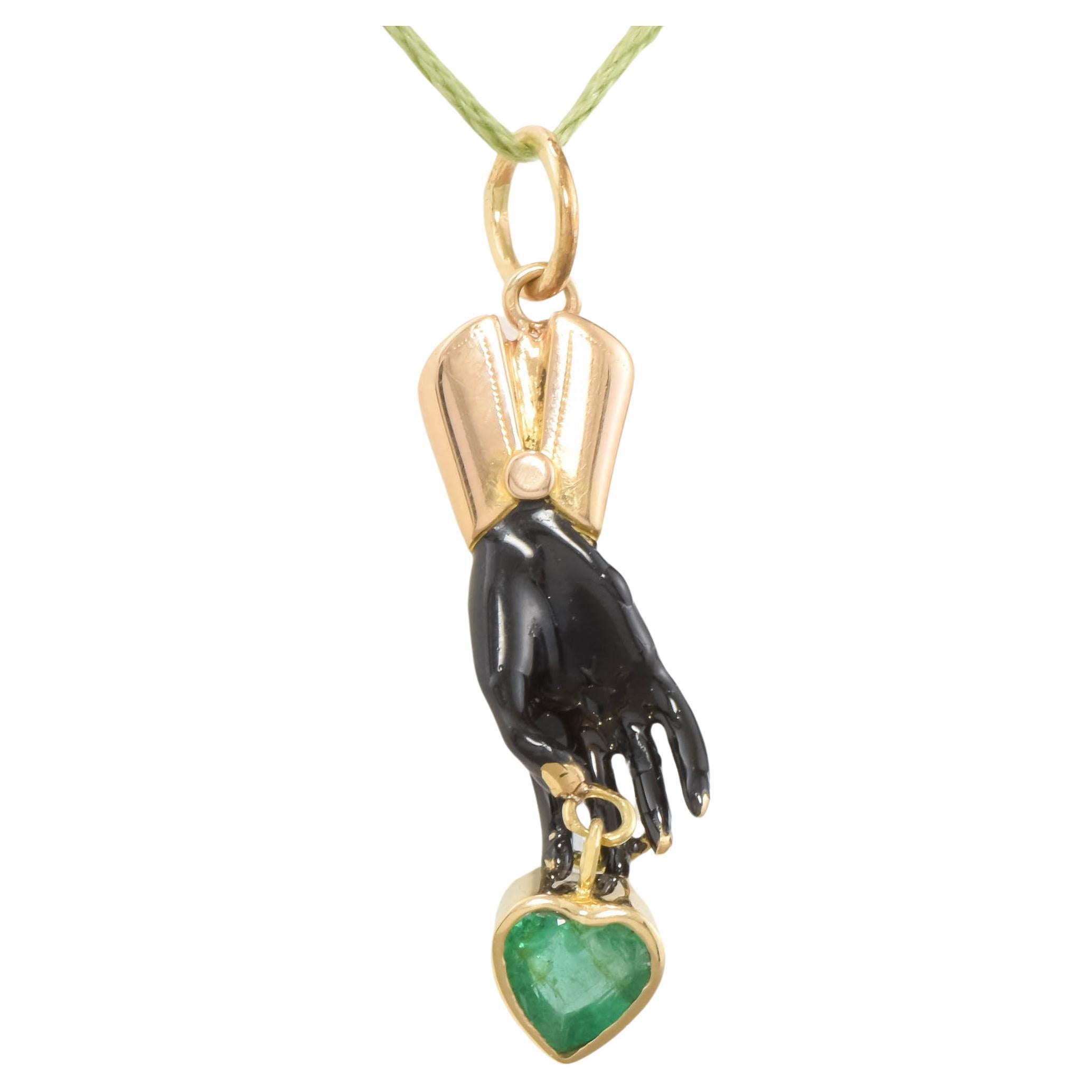 This is a one-of-a-kind pendant charm that was converted from an antique stickpin that had been damaged.  Now it may be enjoyed worn on a chain, with the heart shaped natural emerald drop I have added.

Testing as 18K gold for the hand and buttoned