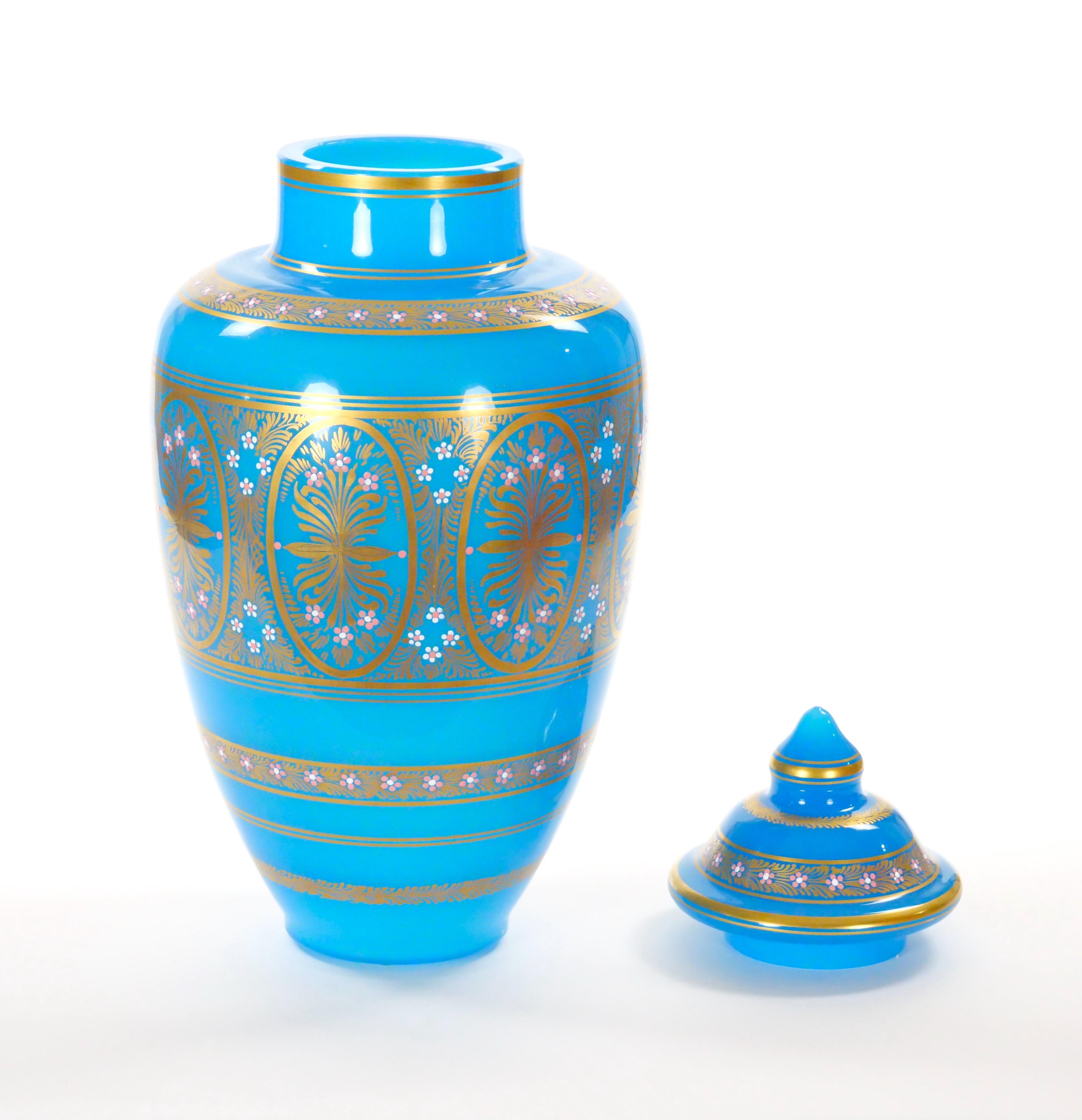 Esta magnífica urna italiana antigua con tapa, fabricada a principios del siglo XIX, es un impresionante ejemplo del arte de la opalina esmaltada. La urna presenta un rico y profundo tono turquesa que sirve de llamativo telón de fondo a su