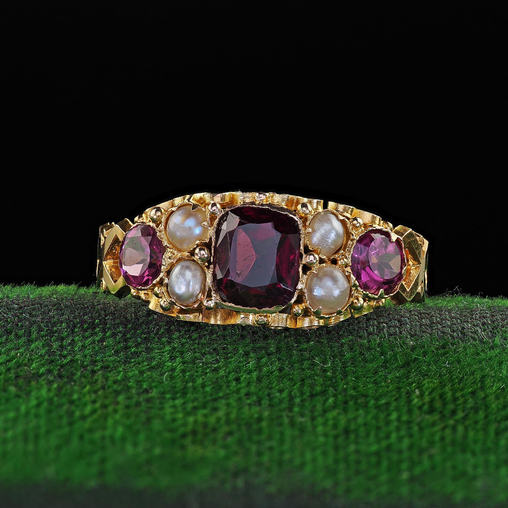 Beautiful Antique English 15K Yellow Gold Rhodolite Garnet and Pearl Ring. This gorgeous Victorian English rhodolite garnet ring is crafted in 15k yellow gold. The ring features a gorgeous rhodolite garnet set in the center and has seed pearls and