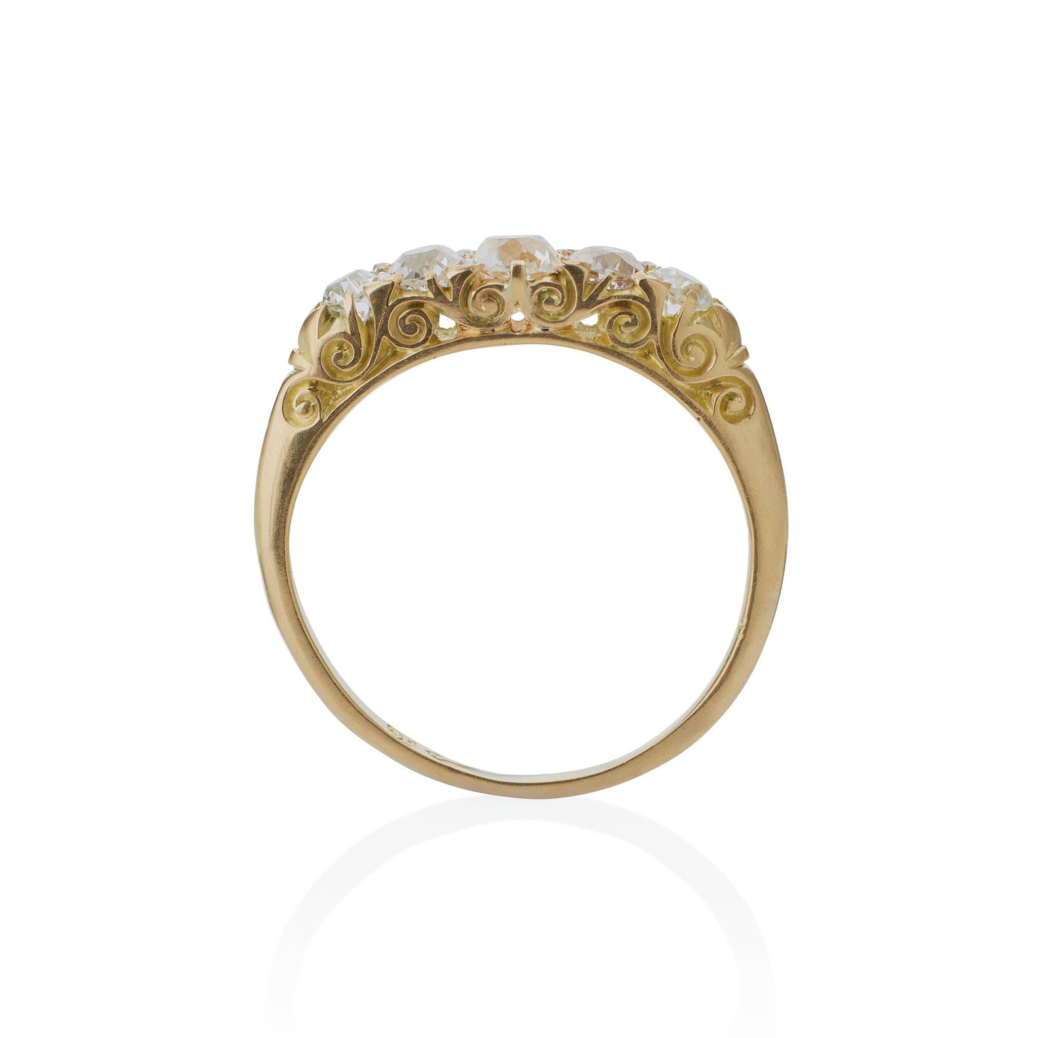 Created in 1893, this antique English diamond ring is set with diamonds mounted in 18K gold, and was made in Chester. The delicate 18K gold band is set across the top with a tapering line of old mine-cut diamonds interspersed with rose-cut diamonds,