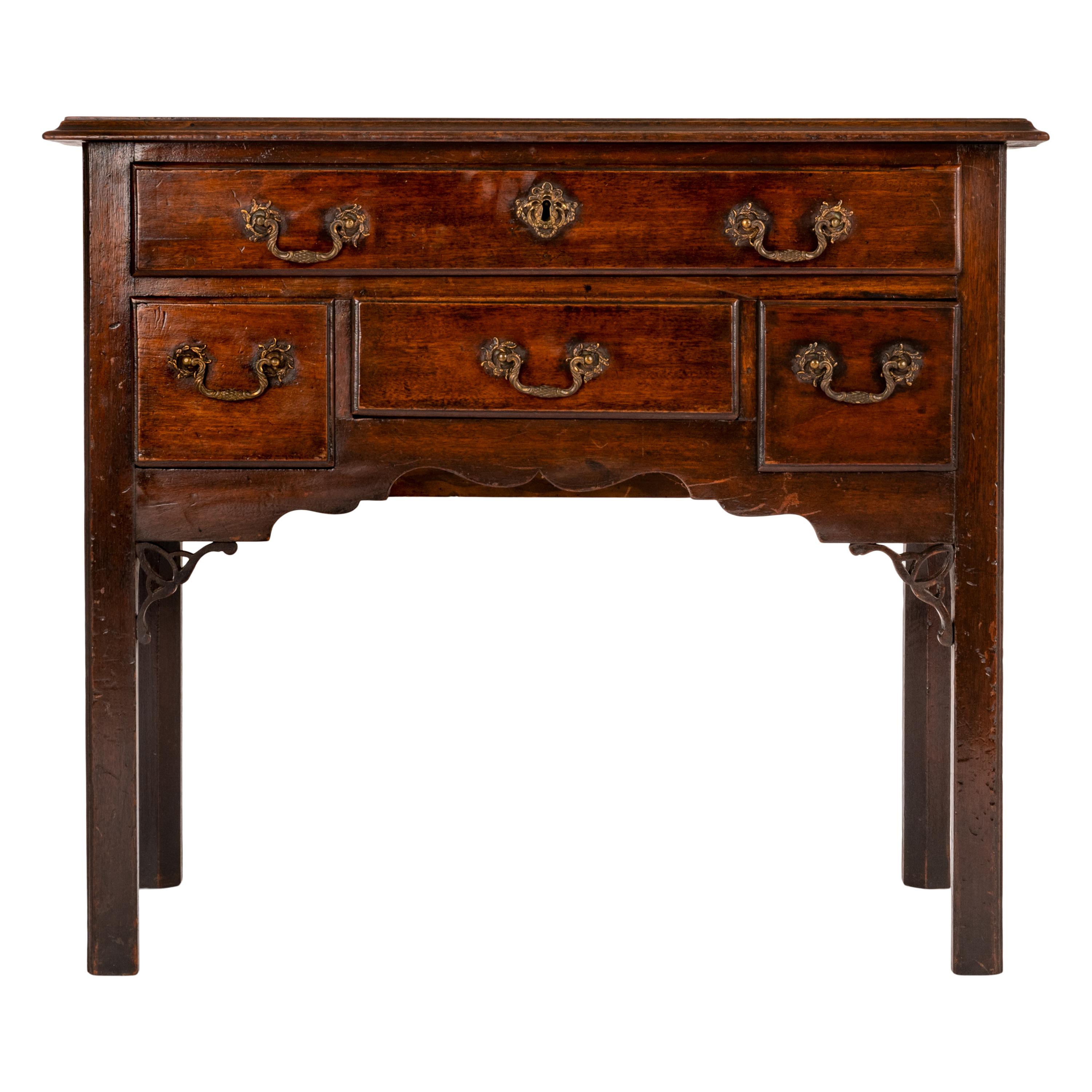 A good antique English Georgian Chippendale mahogany lowboy, circa 1750.
The molded rectangular top overhangs the case, which has one long drawer above three smaller drawers, all are thumb-molded and have the original cast brass Rococo handles and