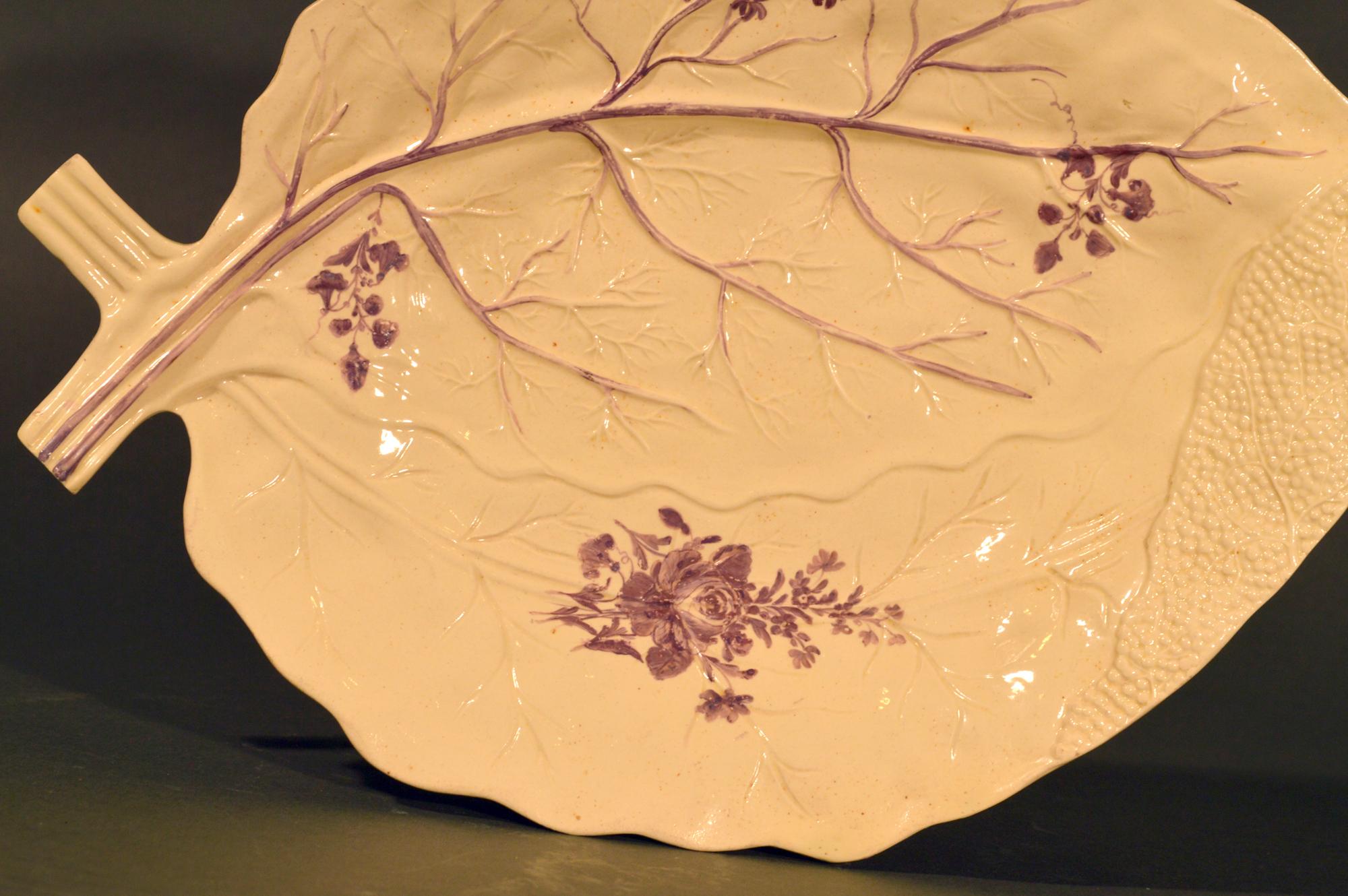 Derbyshire Creamware Blatt Dish,
Um 1785.

Die große Cremeschale aus Derbyshire hat einen naturalistisch geformten Körper in Form von zwei sich überlappenden Blättern mit gemalten violetten Blüten.

Abmessungen: 13 1/4 Zoll x 9 1/4 Zoll x 1 1/4