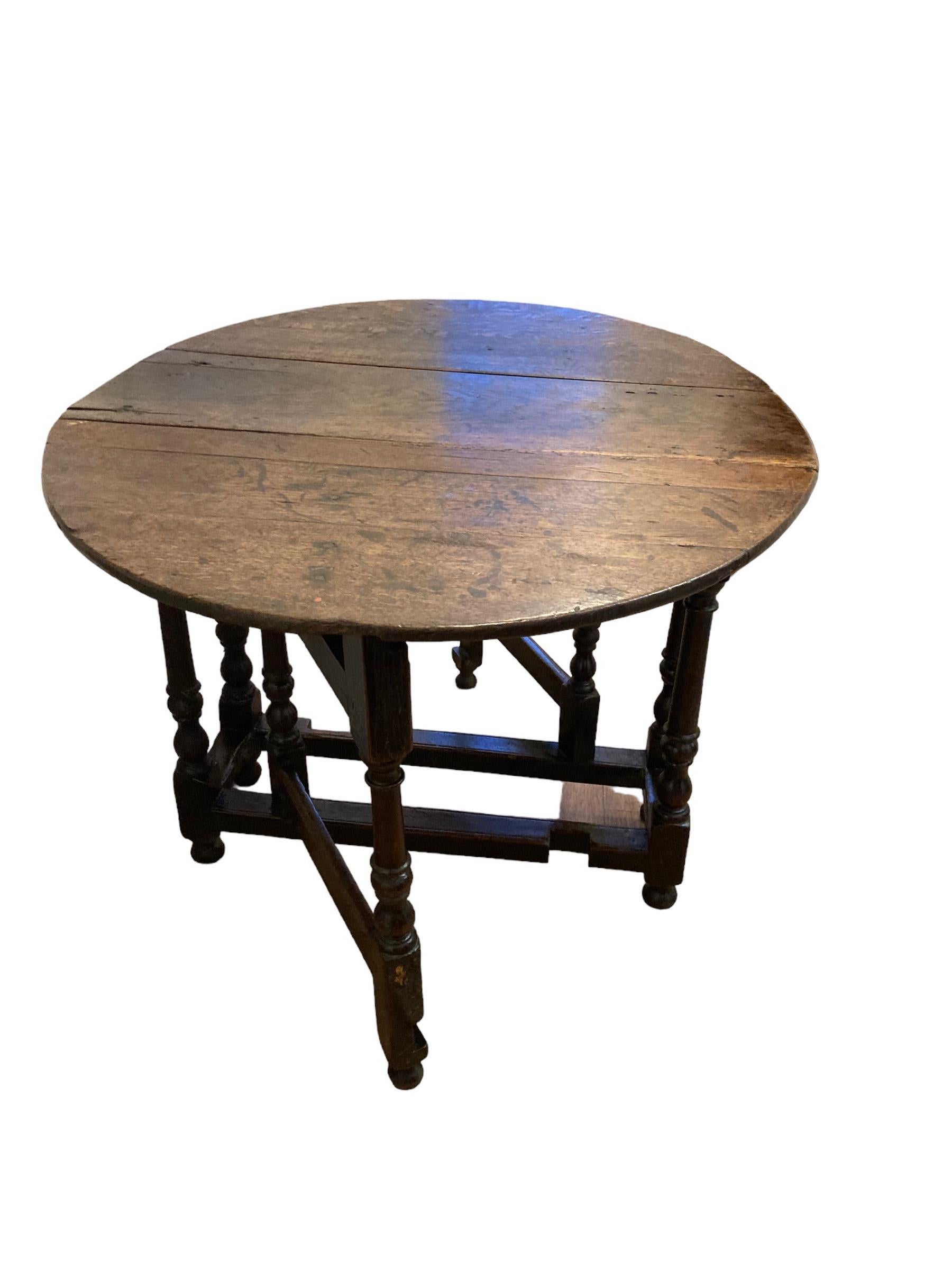 Antique English 18th Century Oak Gate Leg drop leaf Table, on turned column legs. A single draw on one side with round knob handle. This piece is both practical, ornate and a solid item of furniture has 250 years of history in its apearance.

H: 72