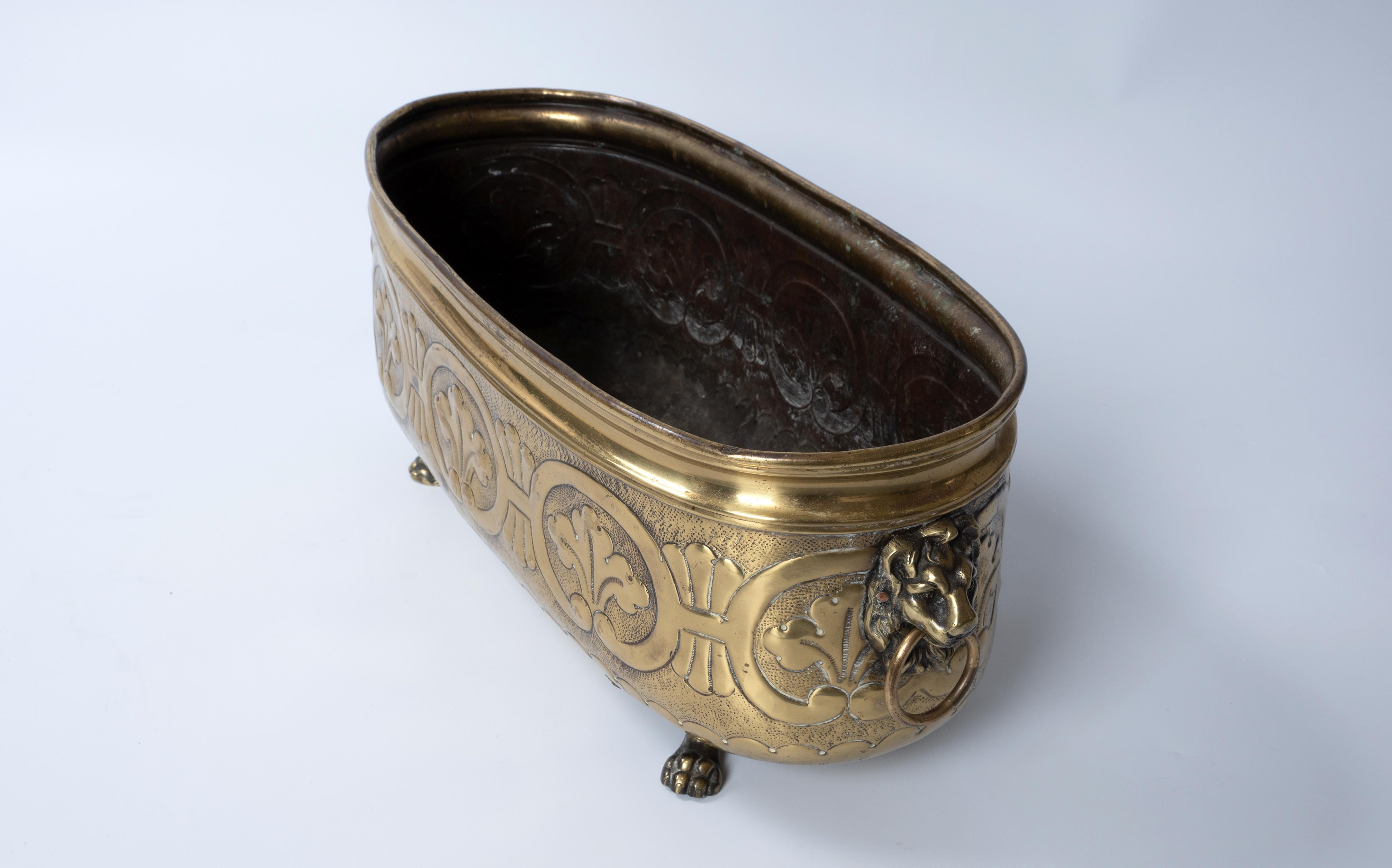Antique English 19th Century Oval Brass Jardinière Planter Lion's Head standing on paw feet.
In good condition with expected signs of wear commensurate of age.
