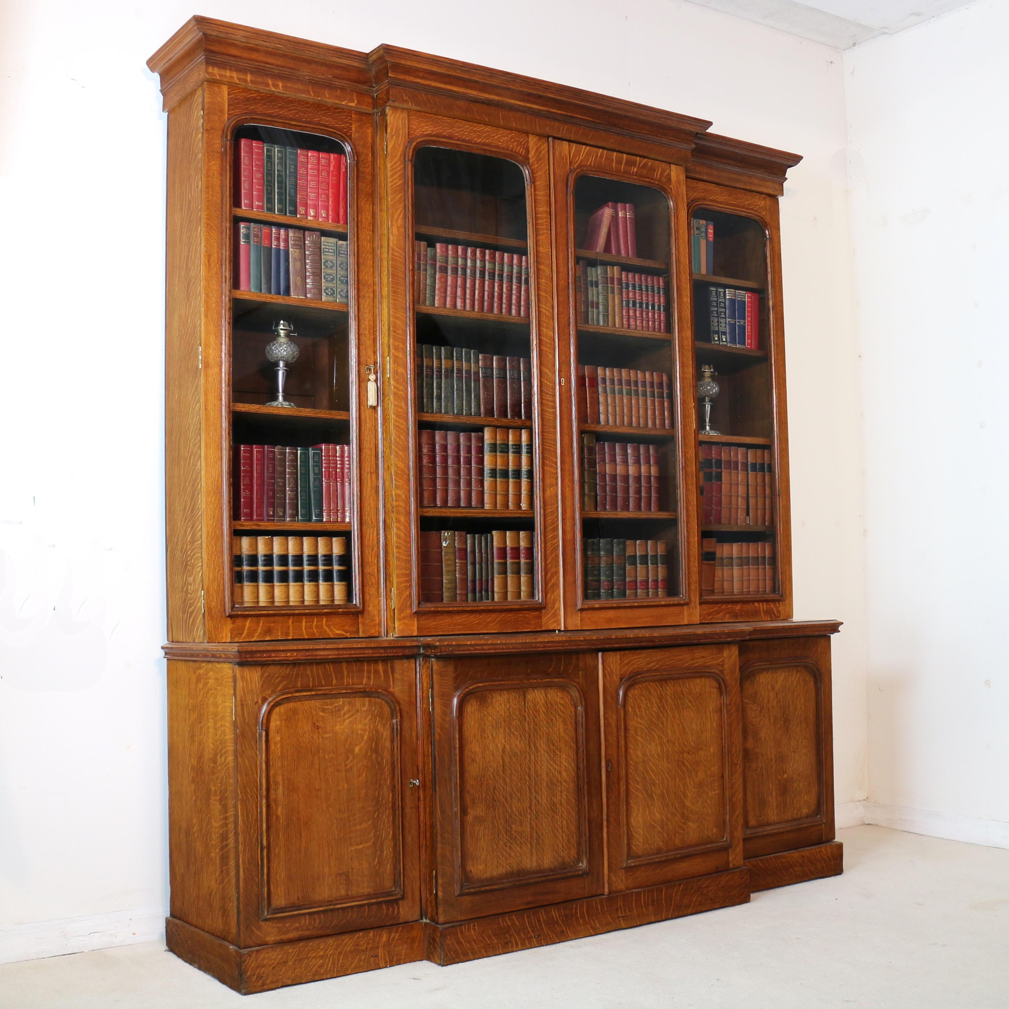 An impressive William IV/early Victorian four door breakfront bookcase or bookcase cabinet. Rare to find such a large bookcase in golden quarter-sawn oak which has the attractive ‘tiger grain’ or medullary rays, it has a square cornered moulded