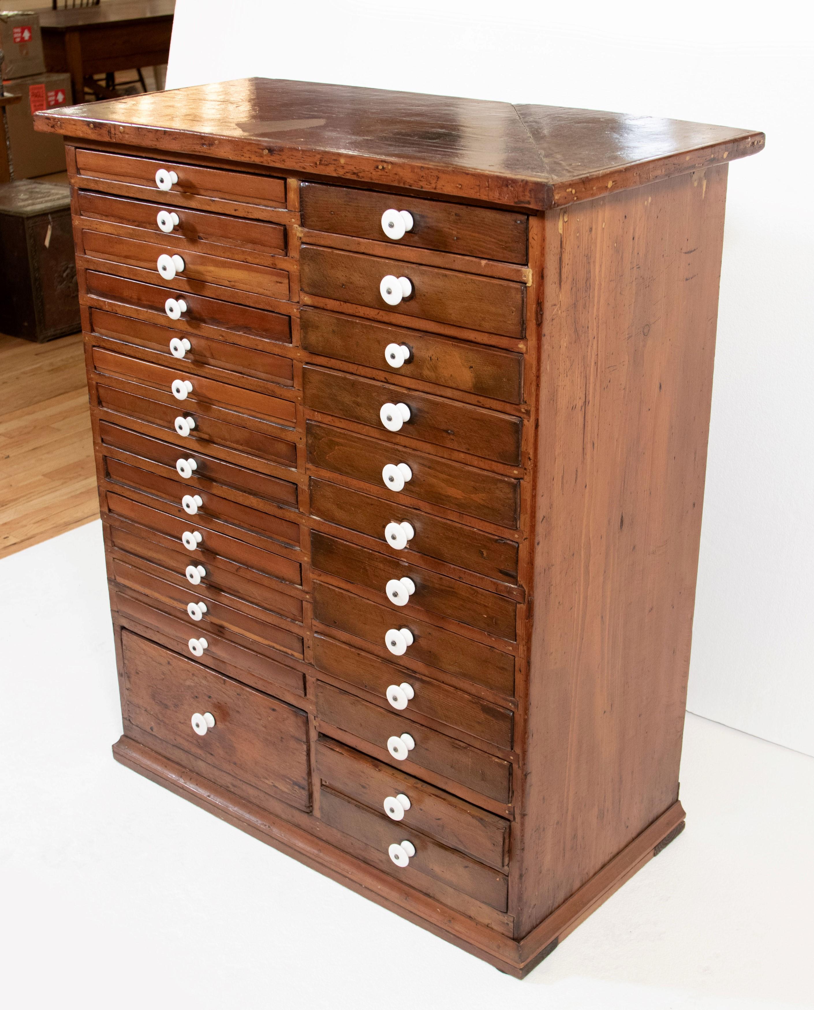 Antique Early 20th Century wood dental cabinet with 26 drawers and white ceramic knobs. Good condition with appropriate wear from age. One available. Please note, this item is located in one of our NYC locations.