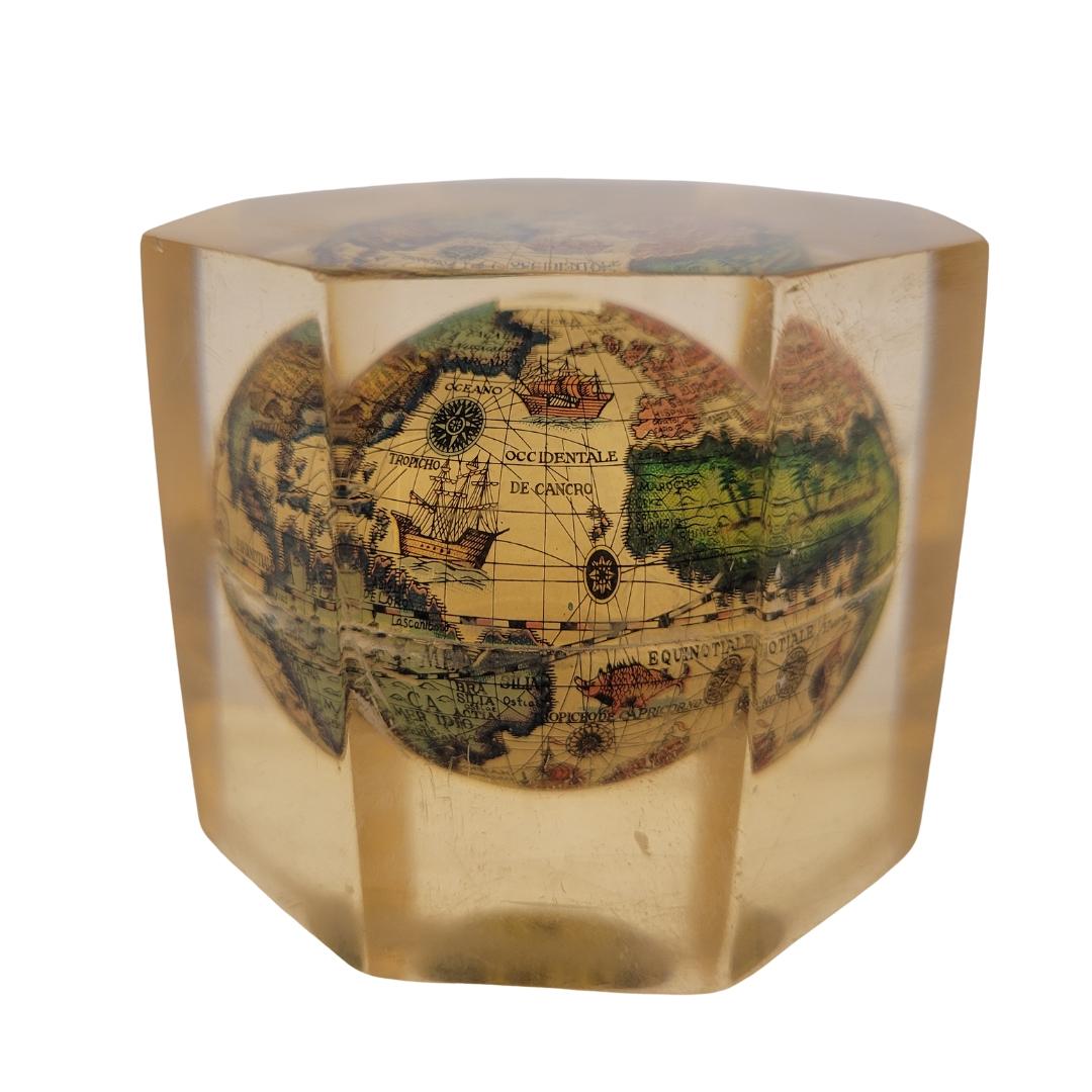 Bellissimo fermacarte antico inglese in metacrilato con un mappamondo all'interno. Un oggetto da collezione.
Questo fermacarte esagonale in metacrilato contiene un piccolo mappamondo nello stile della cartografia del XVIII secolo.
Un oggetto molto