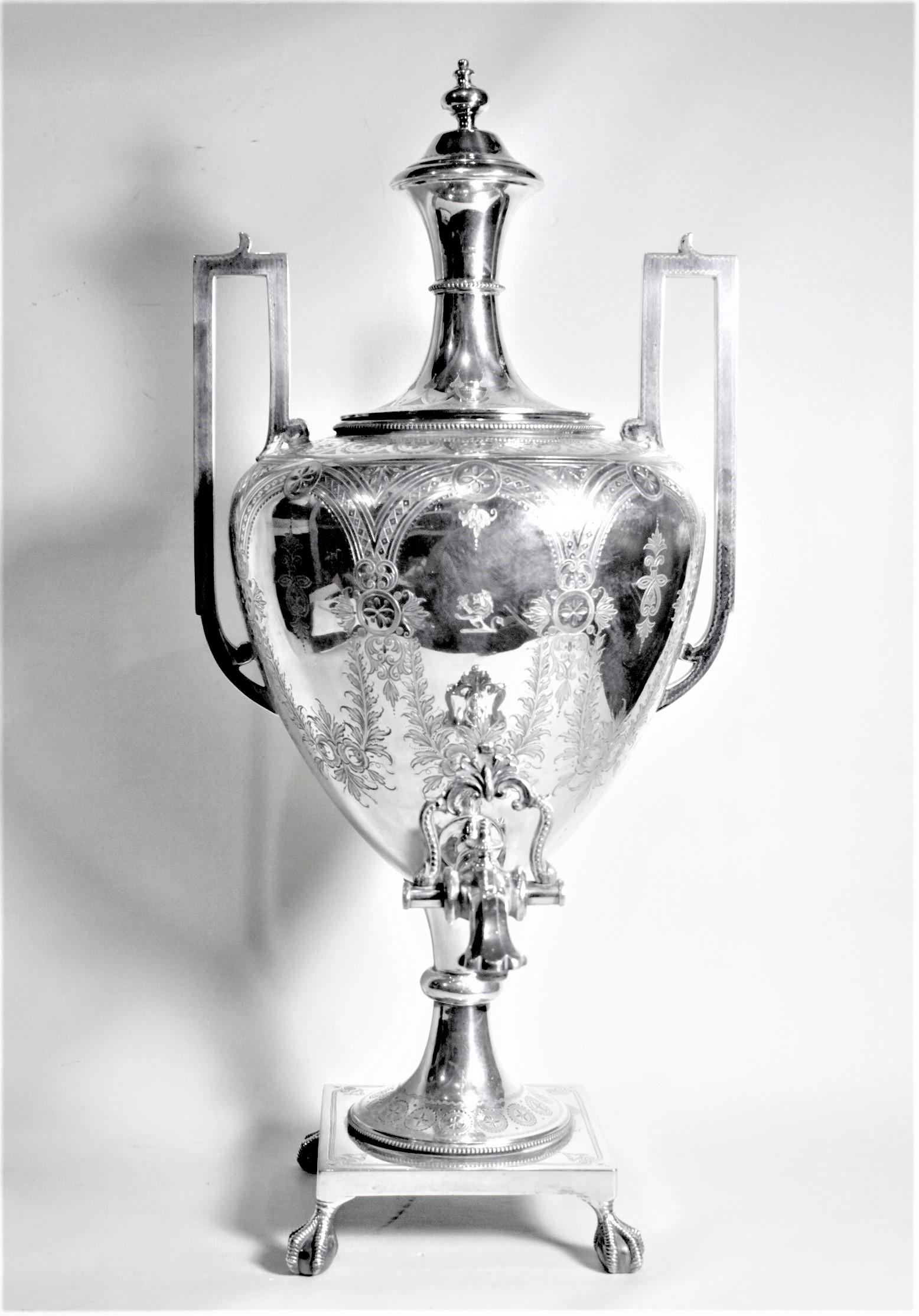 This antique silver plated tea or hot water urn is unsigned, but presumed to have been made in England in circa 1880 in the style of the Aesthetic Movement. The tapered cylindrical shape of the lid and bulbous shaped body are accented by the bold