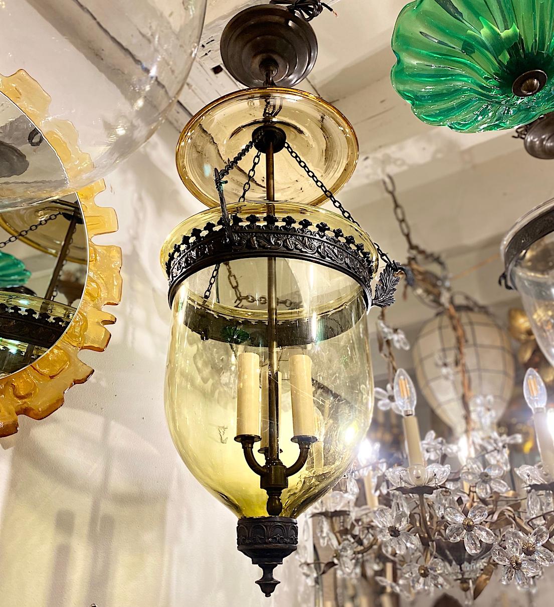 A circa 1900 English patinated bronze glass lantern with 3 interior lights.

Measurements:
Drop: 30