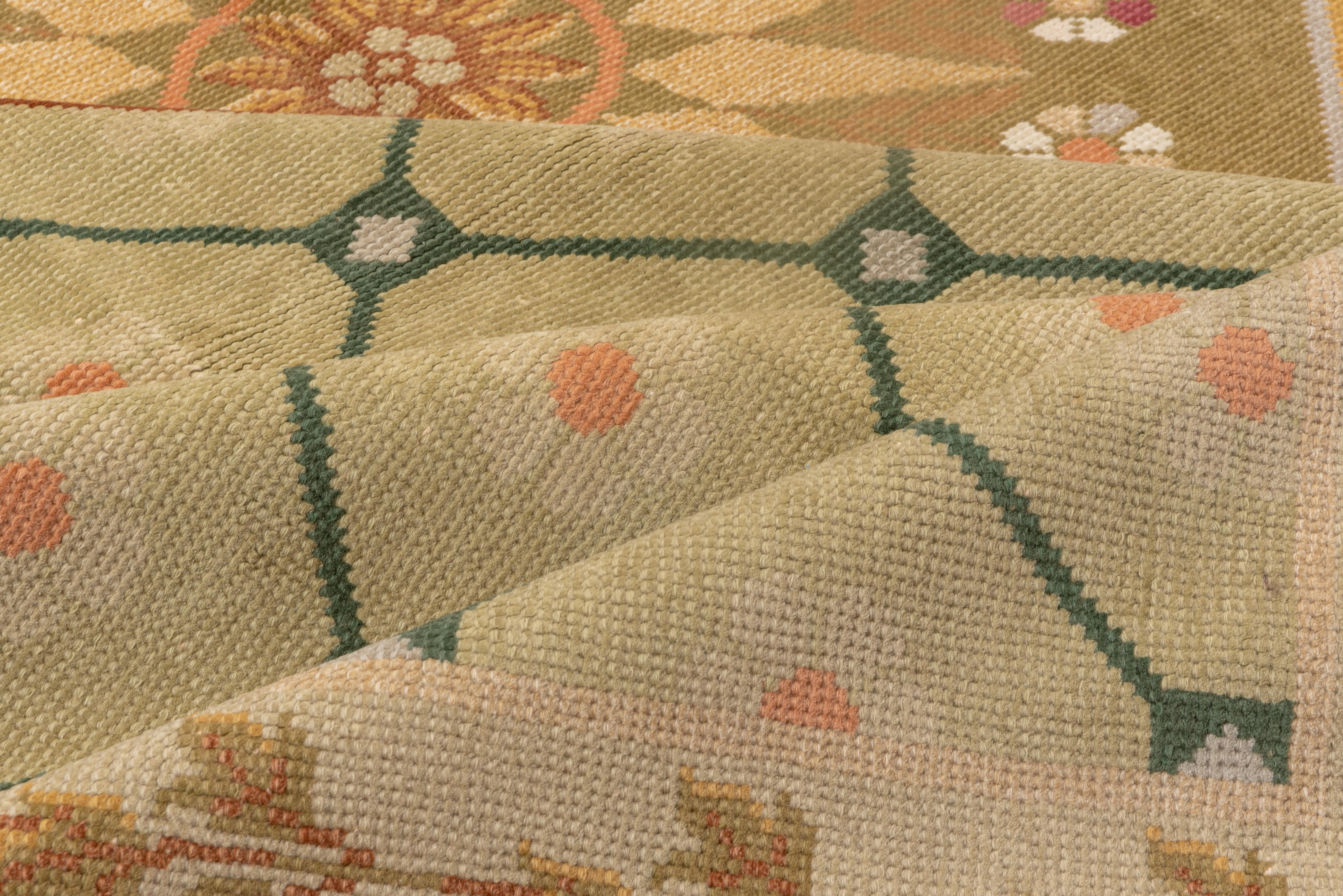 In a late Deco/ Moderne style, the pale straw field supports a diamond lattice overlaid by a bold octagonal medallion in rust, with a conforming gold surround with laurel leaf decoration. Giant 16 point central star. Ecru border of green triple leaf
