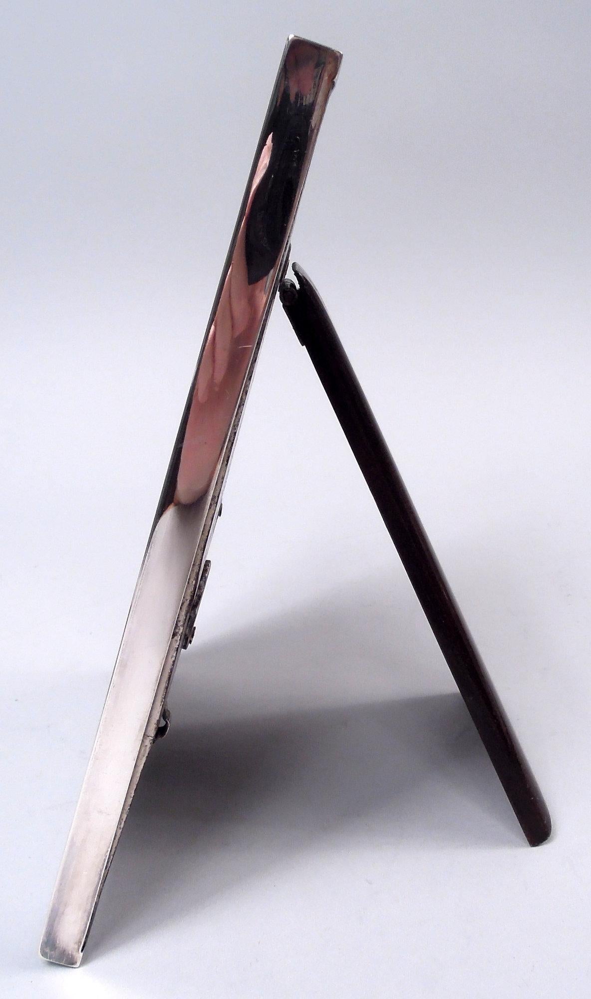 Cadre en argent de George VI. Fabriqué par William Neale & Son Ltd à Birmingham en 1939. Entourage rectangulaire plat. Sur le devant, doublure enveloppante guillochée ; côtés unis. Avec verre, doublure en soie, dos en bois teinté et support de
